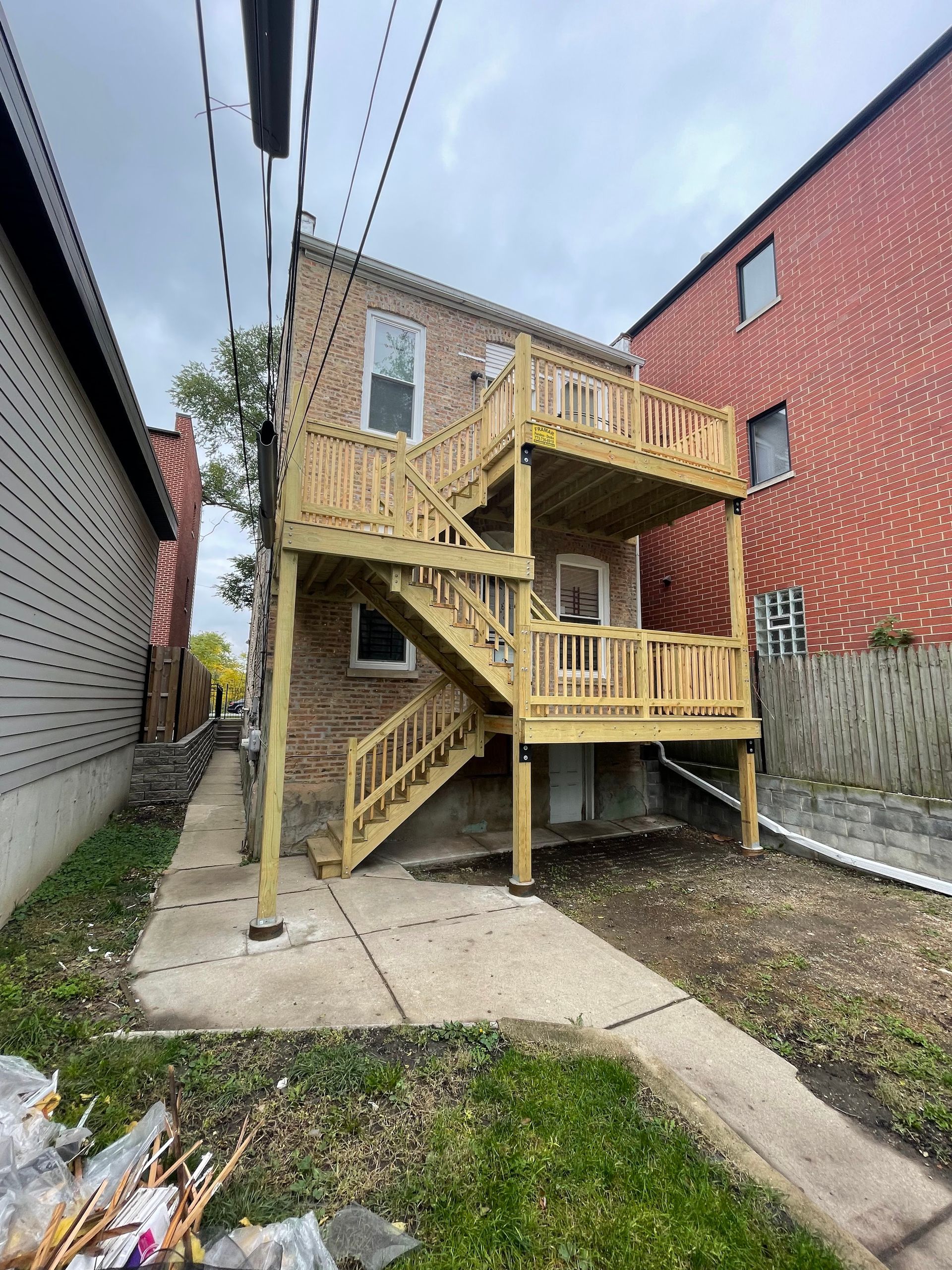 A house with a wooden deck and stairs in the backyard.