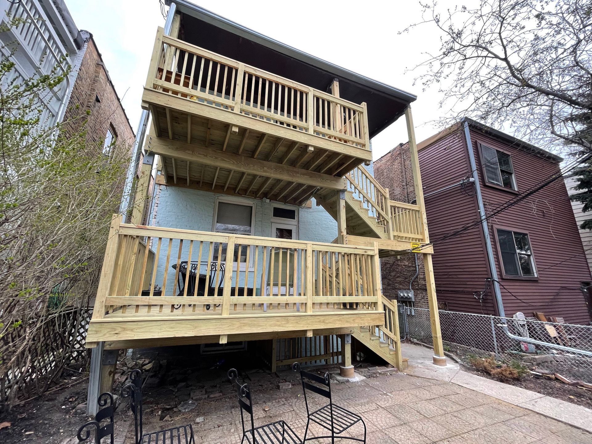 The back of a house with a wooden deck and stairs.
