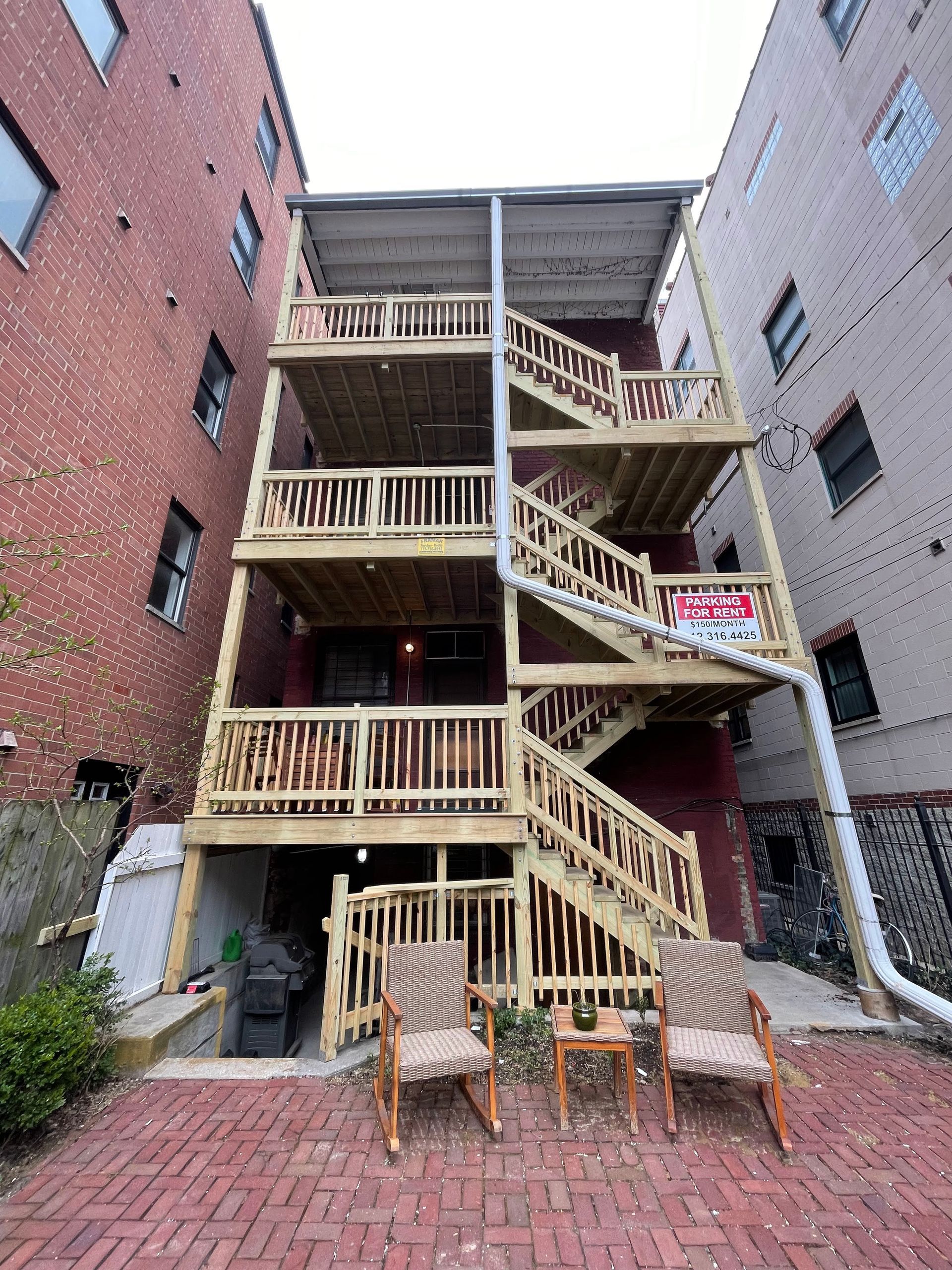 A brick building with a wooden deck and stairs.