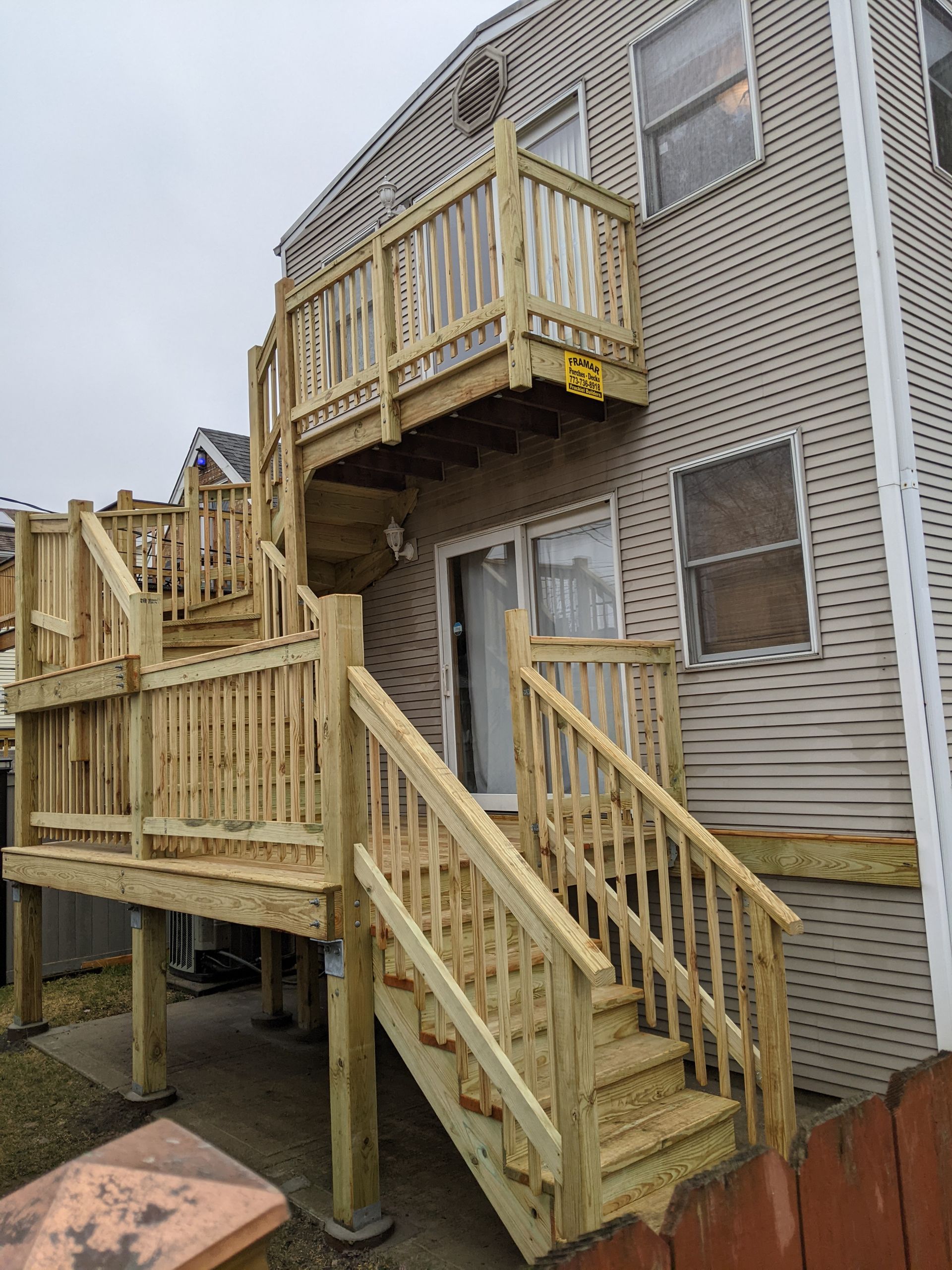 A house with a wooden deck and stairs leading up to it.