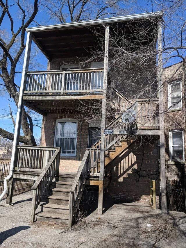 A house with a balcony and stairs on the side of it.