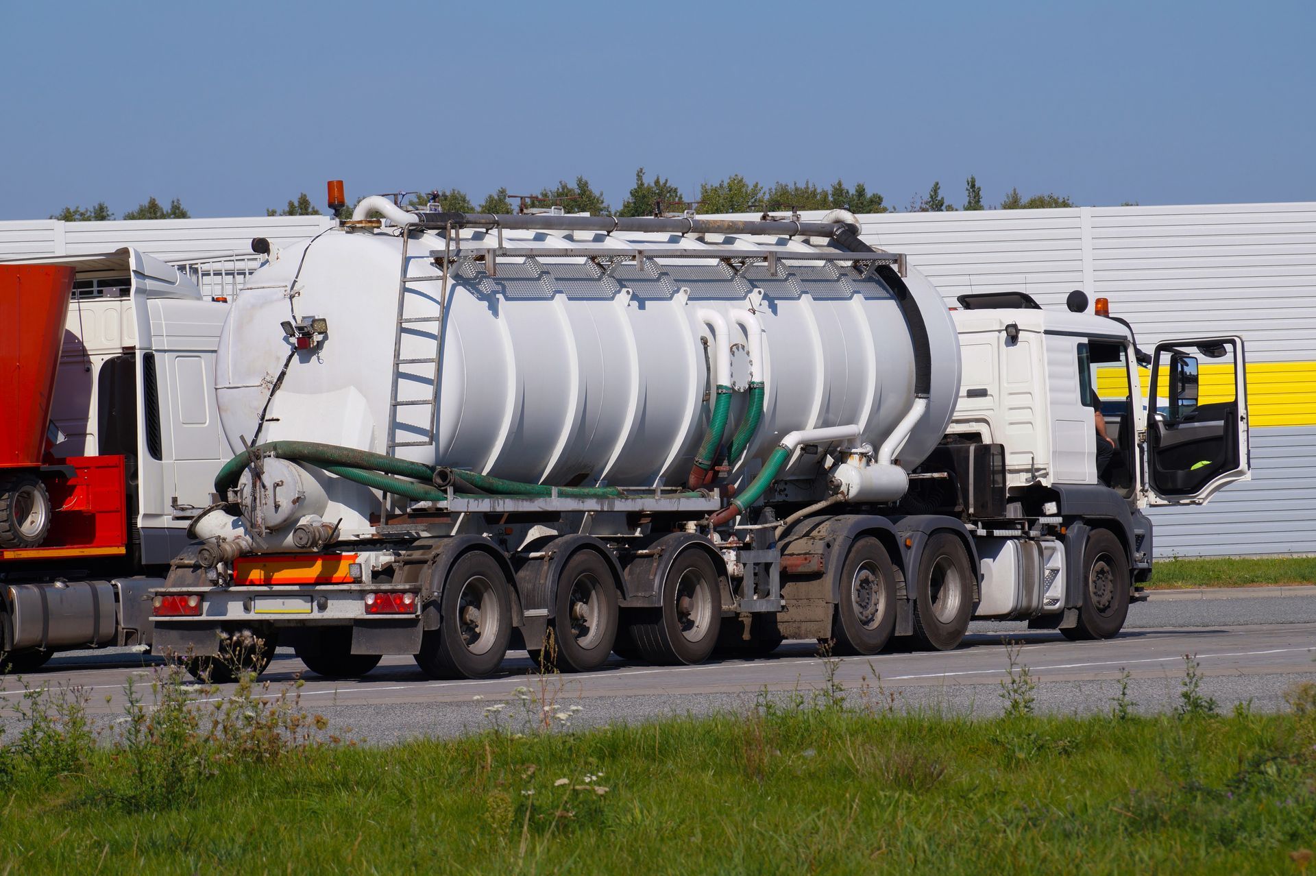 White septic tank truck parked on asphalt.
