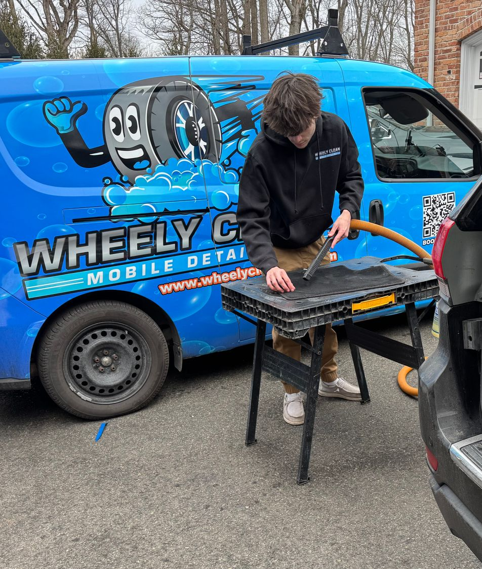 Man working on a car using a table; a 