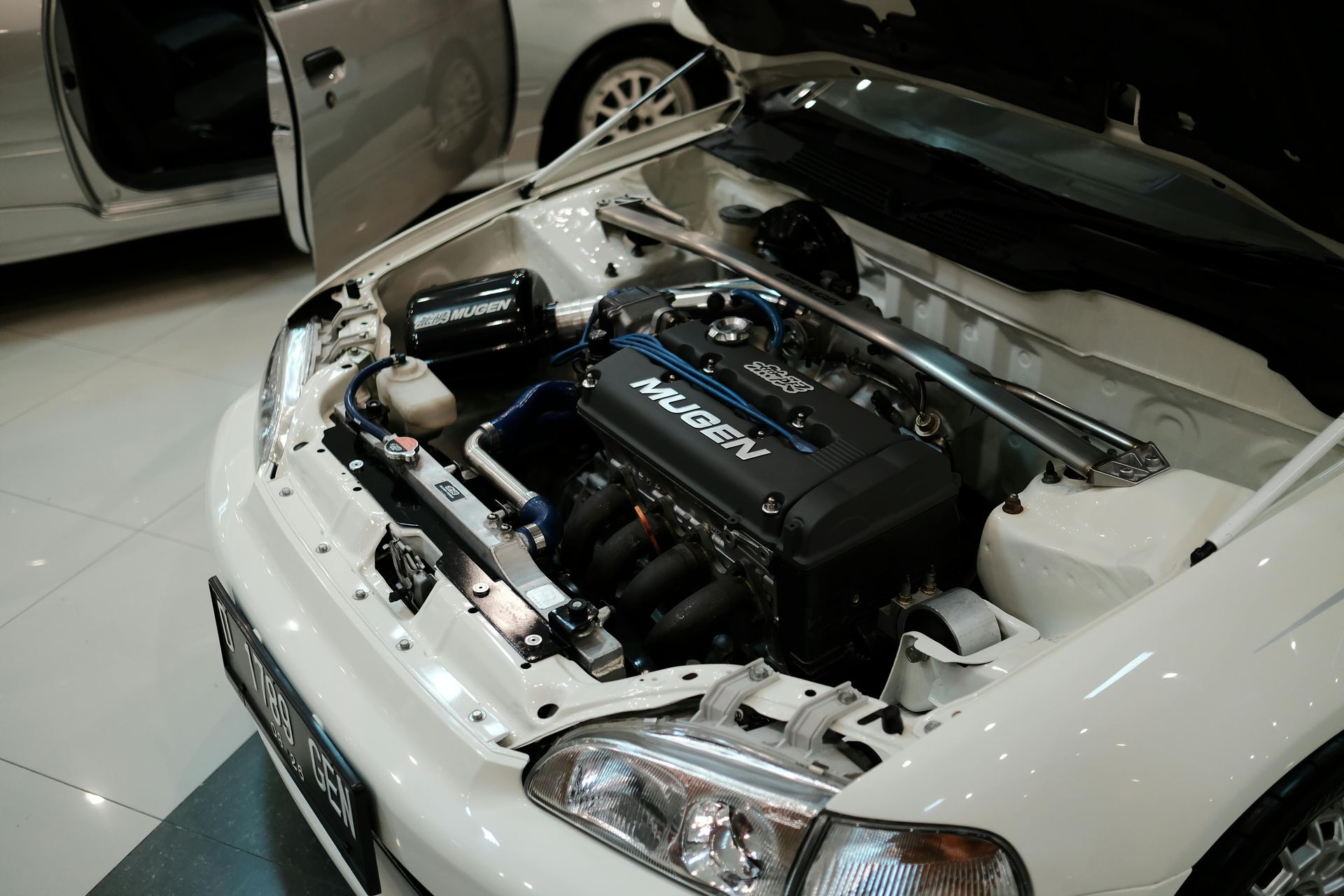 White car engine bay, customized with performance parts.