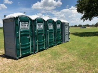 Portable Potty Delivery — Portable Toilets in Horizontal Line in Tampa Bay, FL