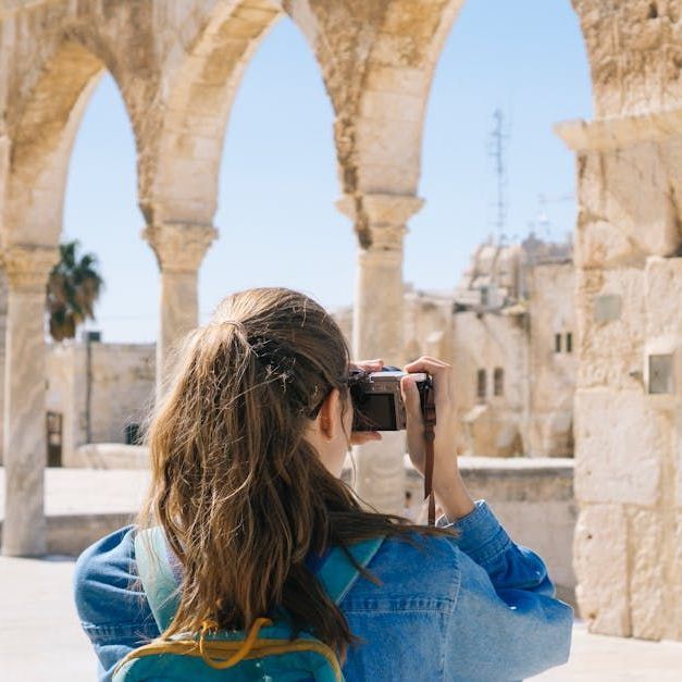 Woman taking photos of stone architecture with arches, Jerusalem, Israel.