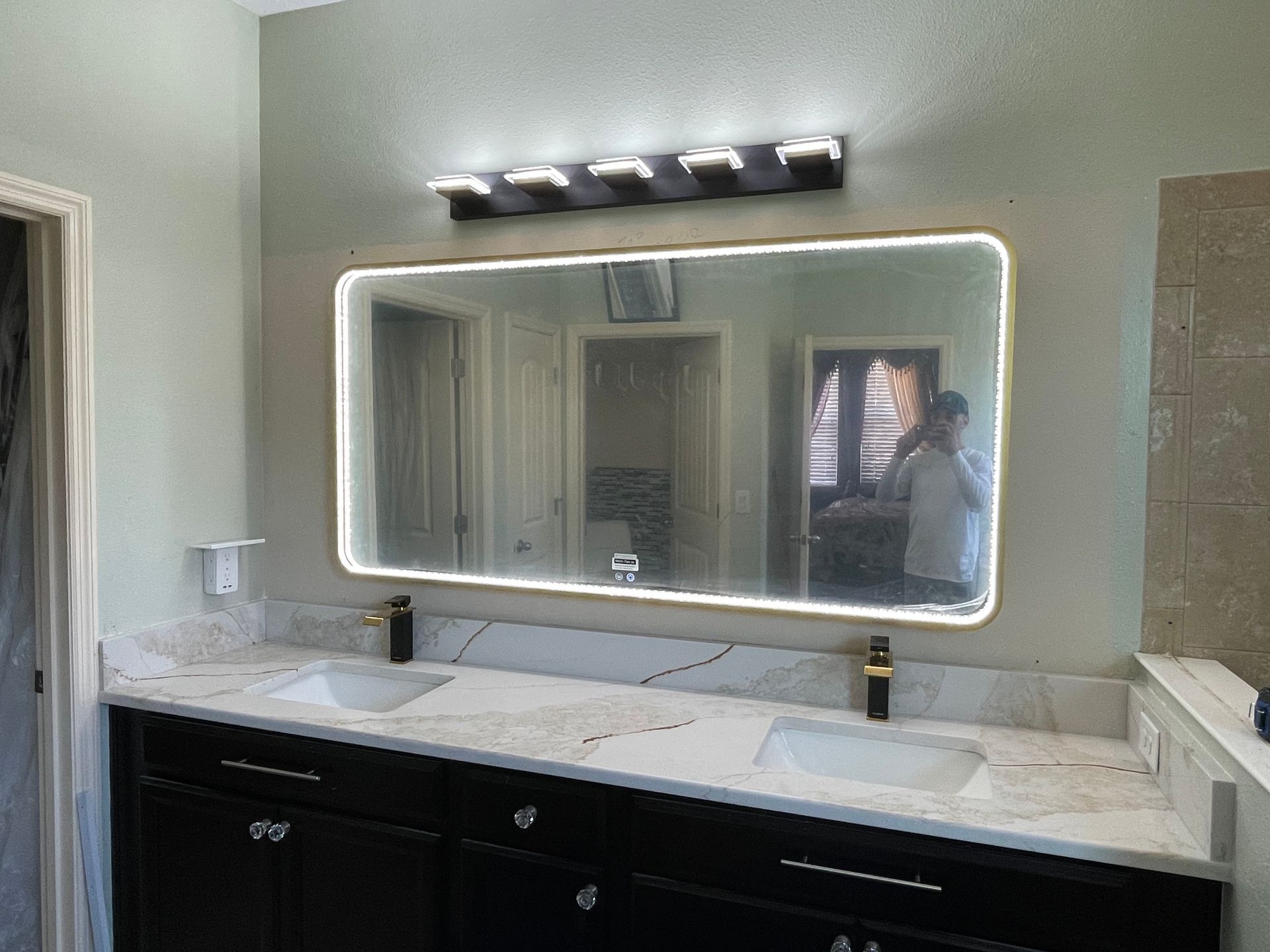 A bathroom with two sinks and a large mirror.