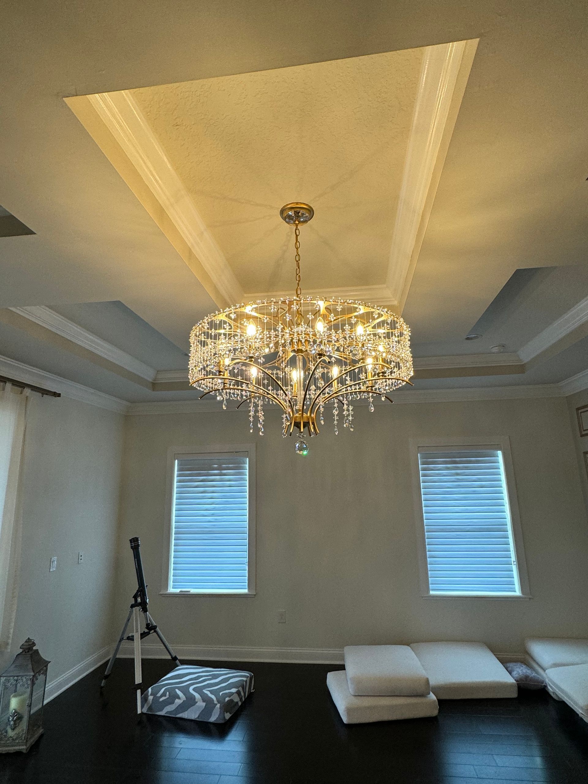A large chandelier is hanging from the ceiling of a living room.