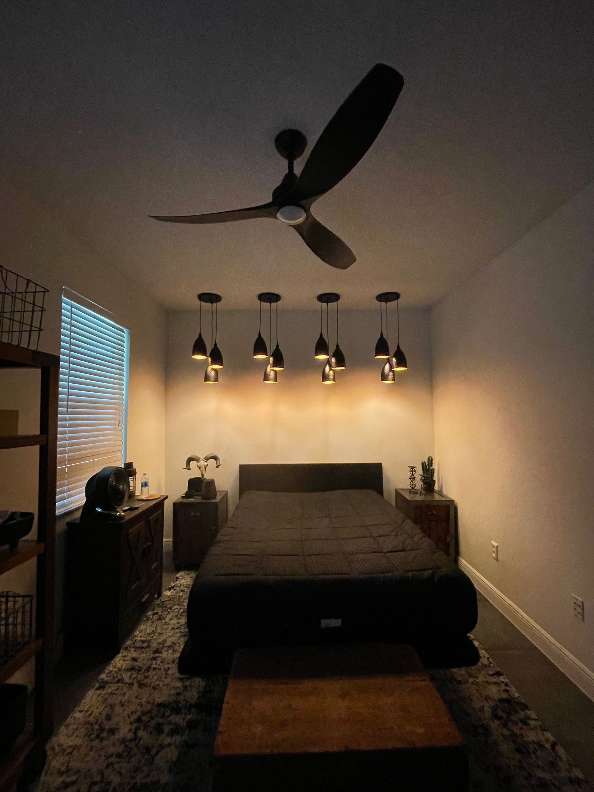 A bedroom with a bed and a ceiling fan.