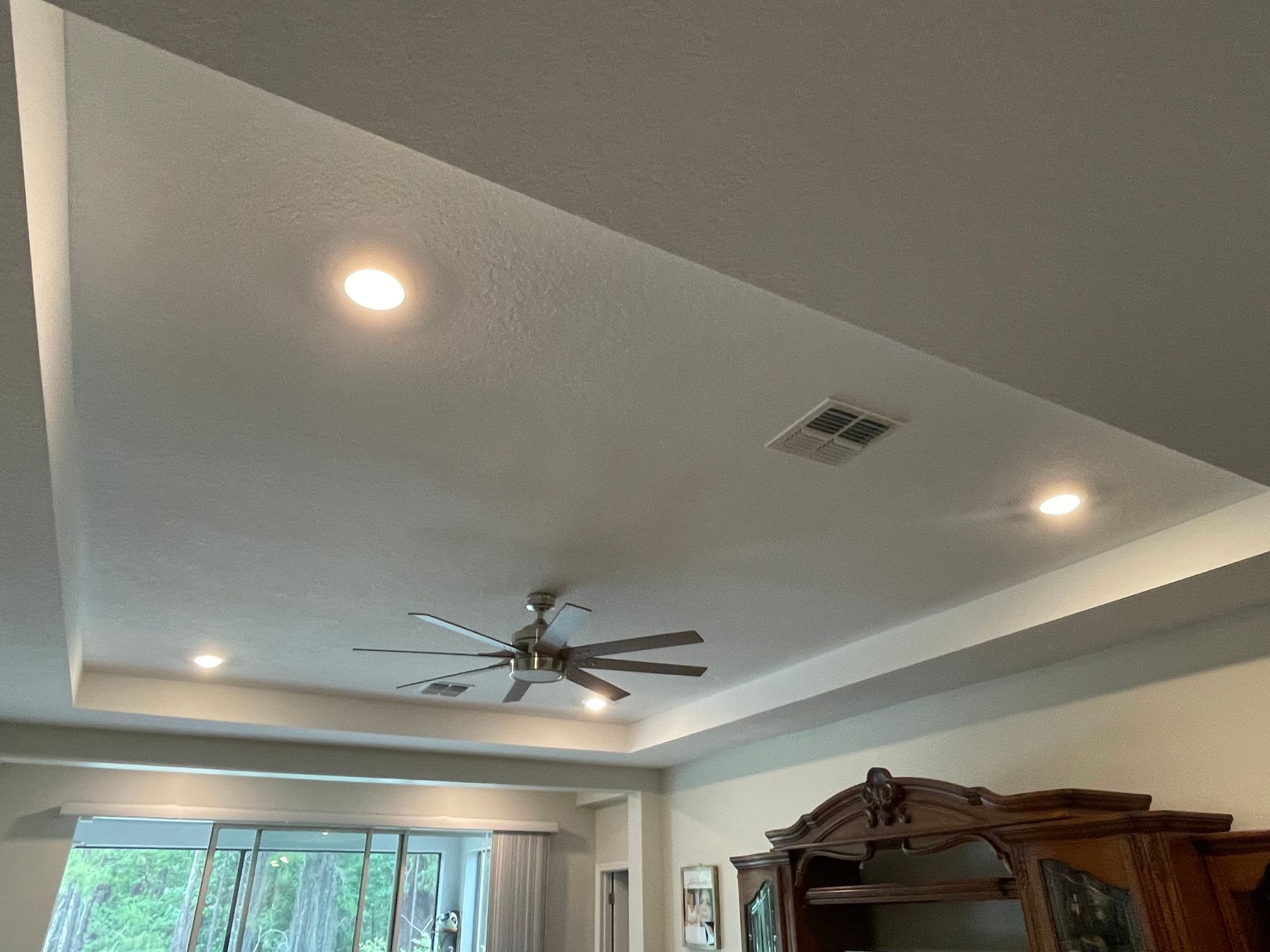 A ceiling fan is hanging from the ceiling of a living room.