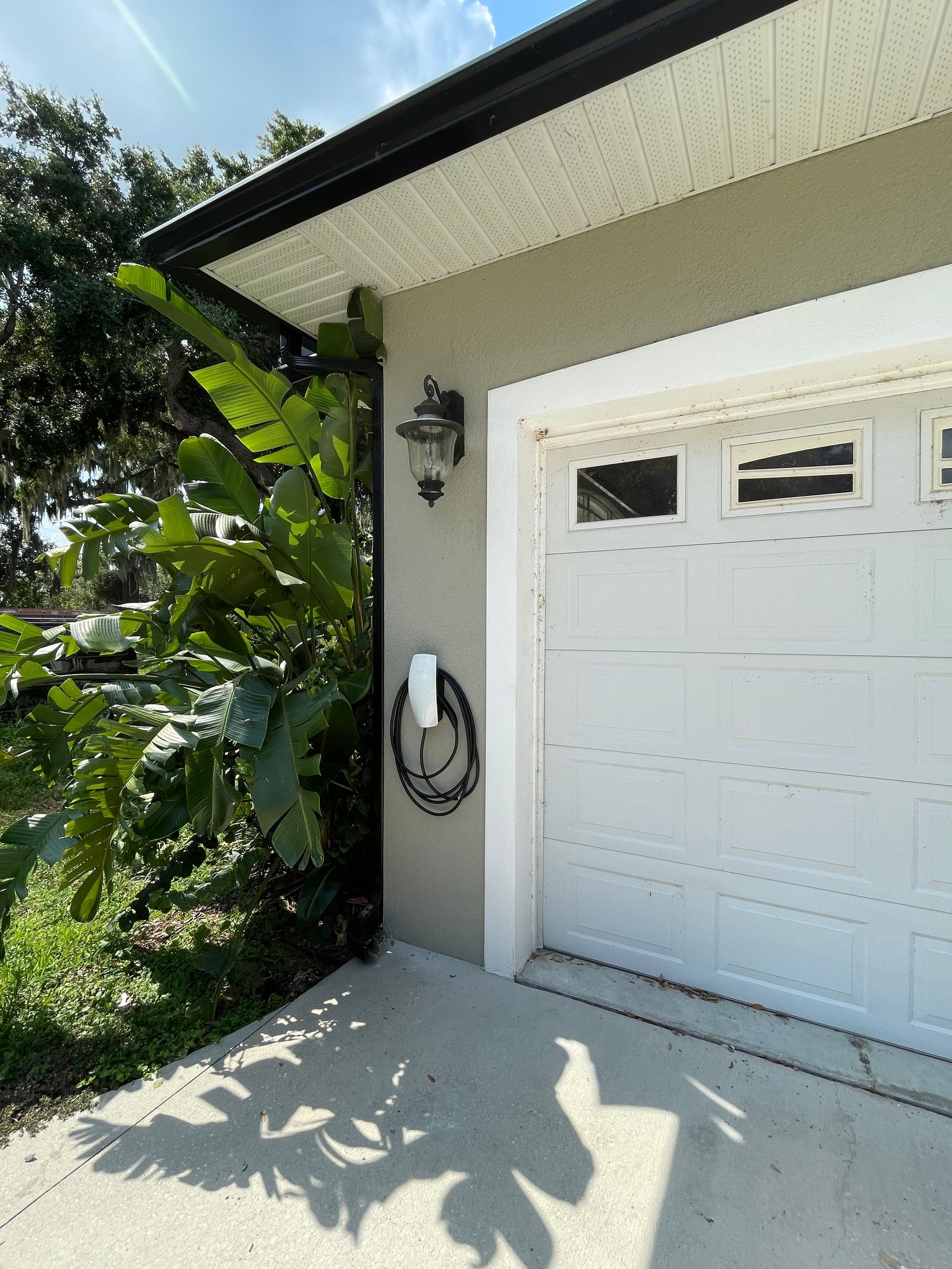 A white garage door is on the side of a house.