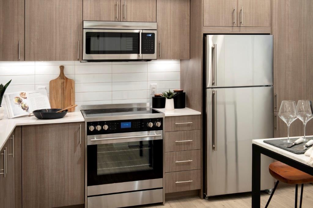 Modern kitchen with stainless steel appliances, including microwave, stove, and refrigerator.