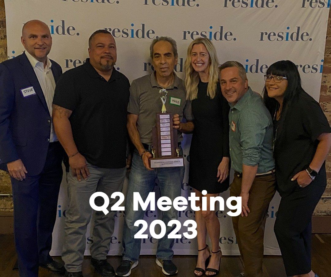 A group of people posing for a picture with a man holding a trophy