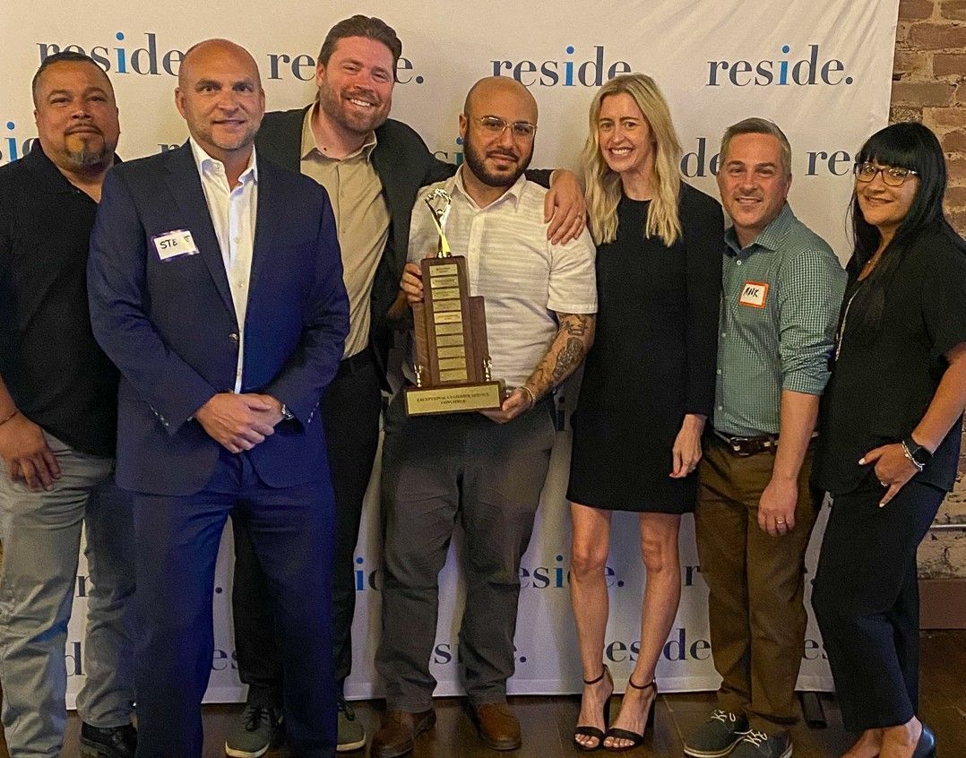 A group of people standing next to each other holding a trophy.