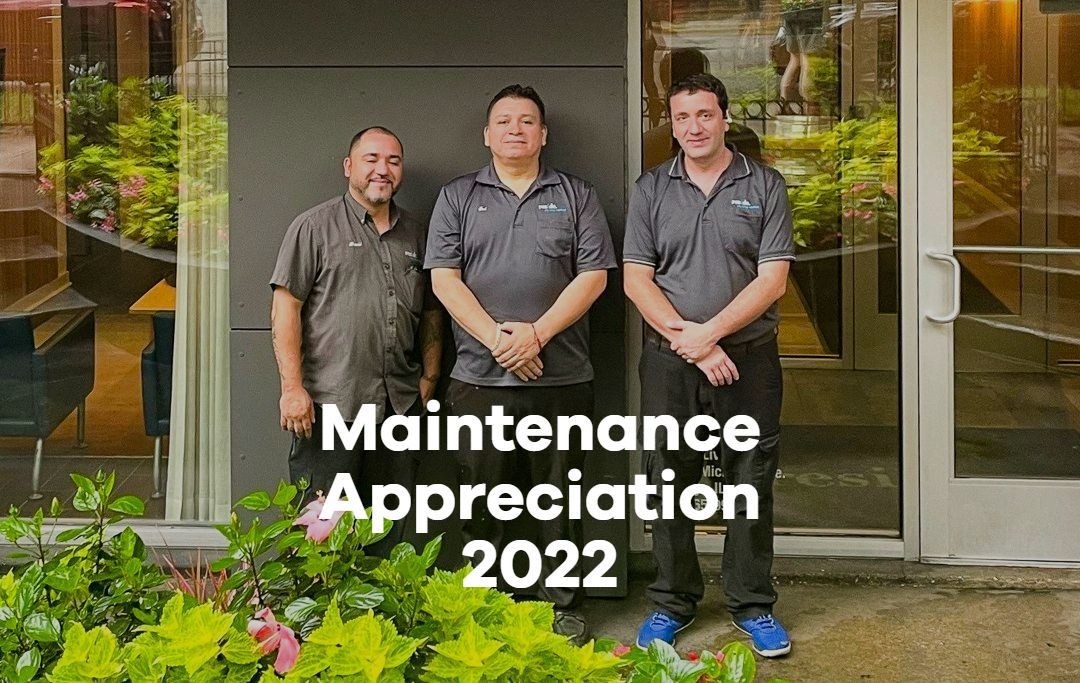Three men are standing in front of a building.