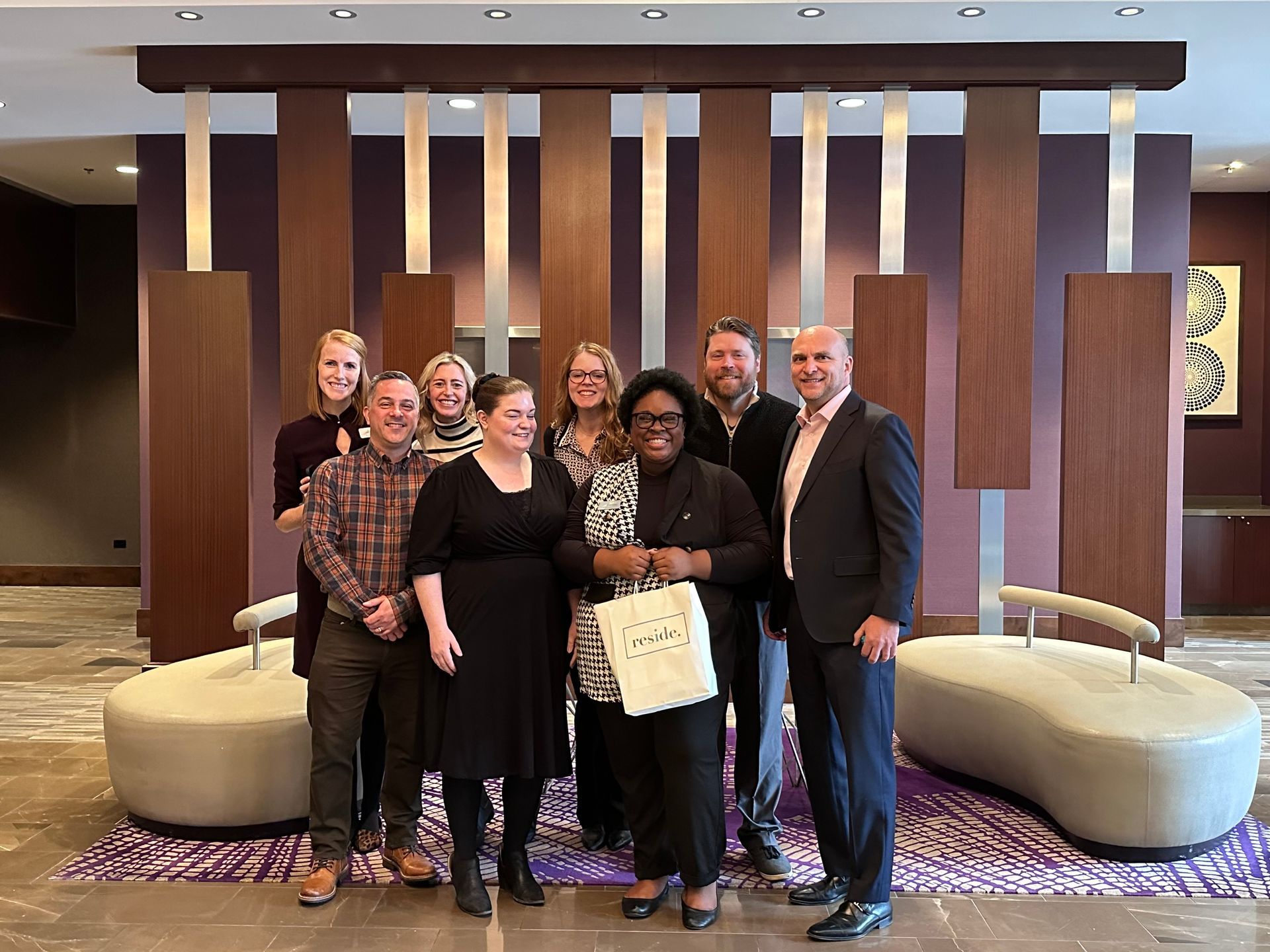 A group of people are posing for a picture in a lobby.
