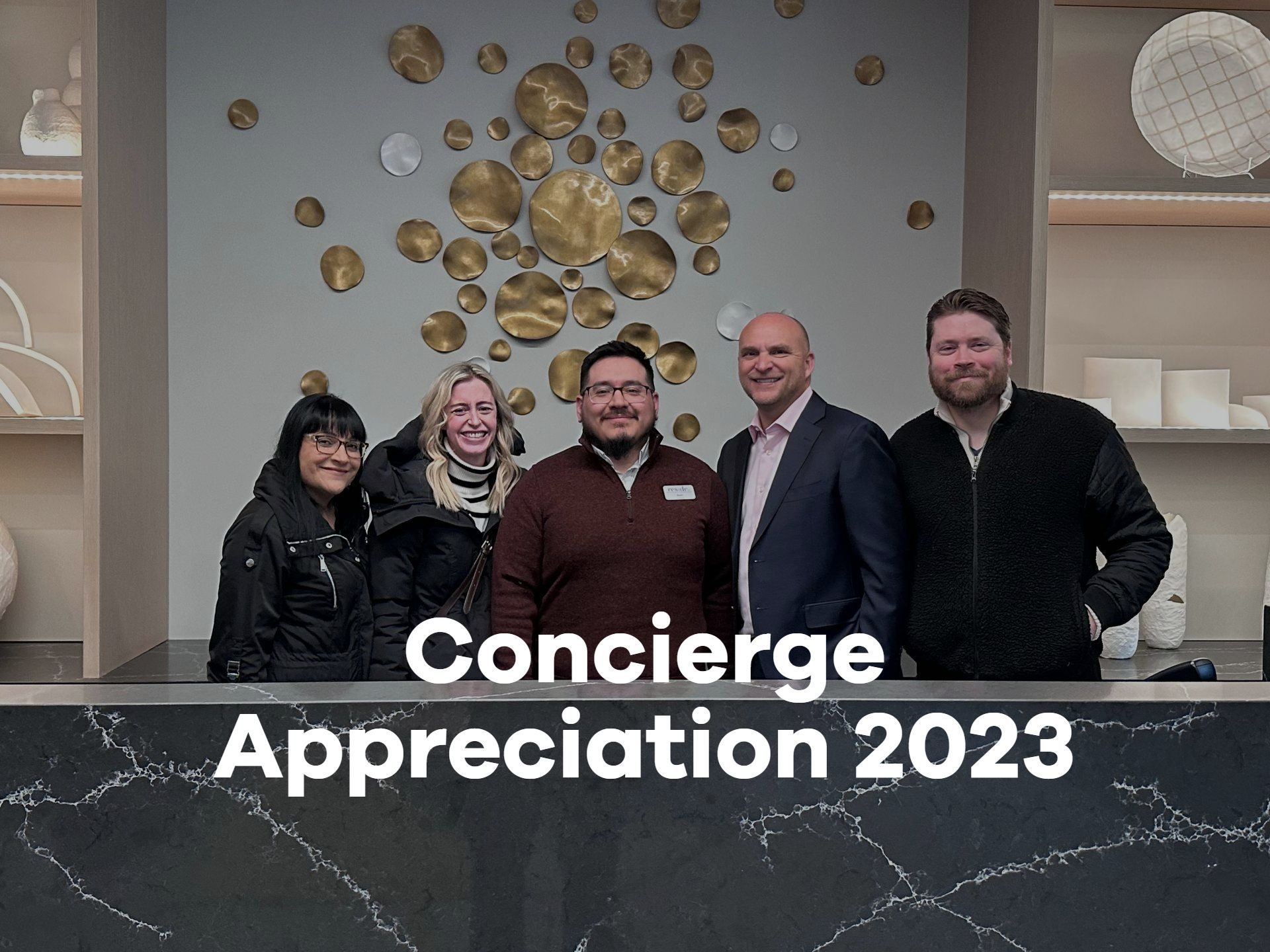 A group of people are posing for a picture in front of a sign that says concierge appreciation 2023