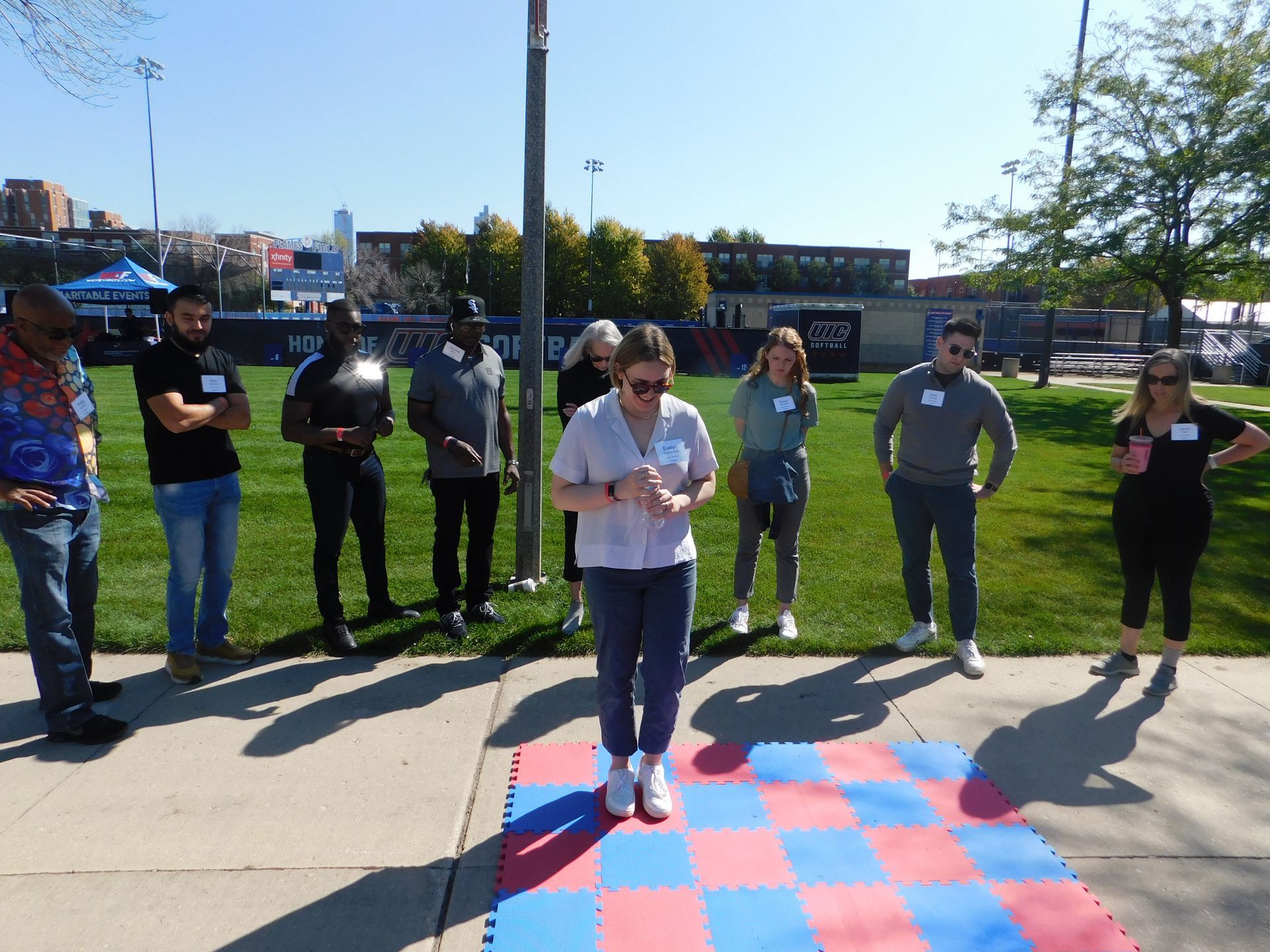 A group of people standing around a checkered mat