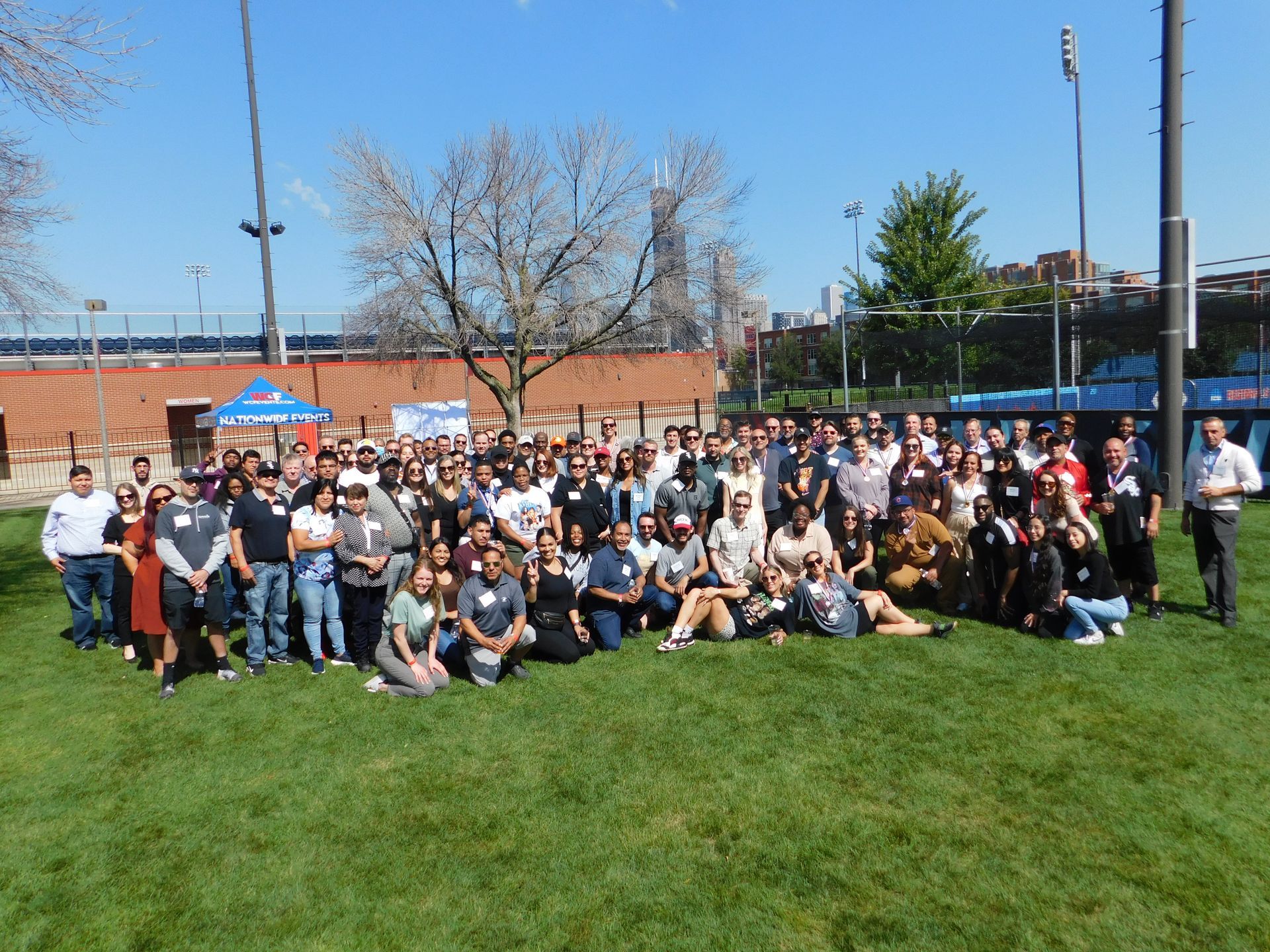A large group of people are posing for a picture in a park.