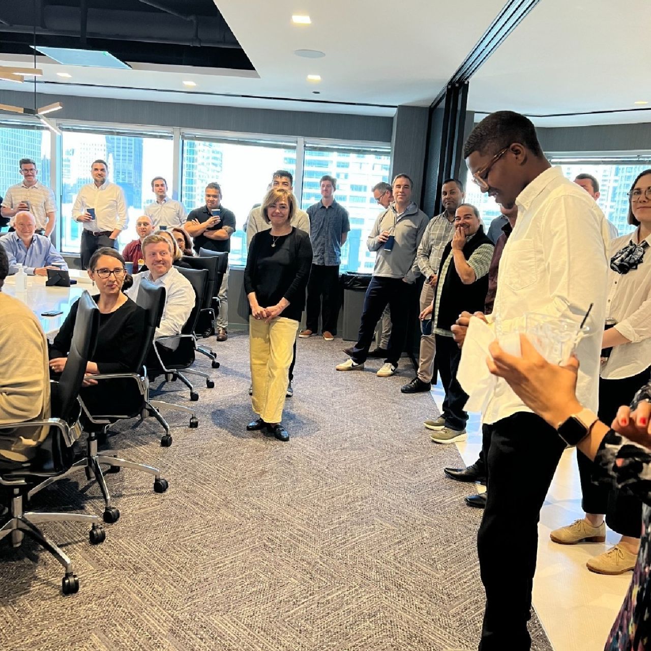 A group of people are standing around a table in a room.