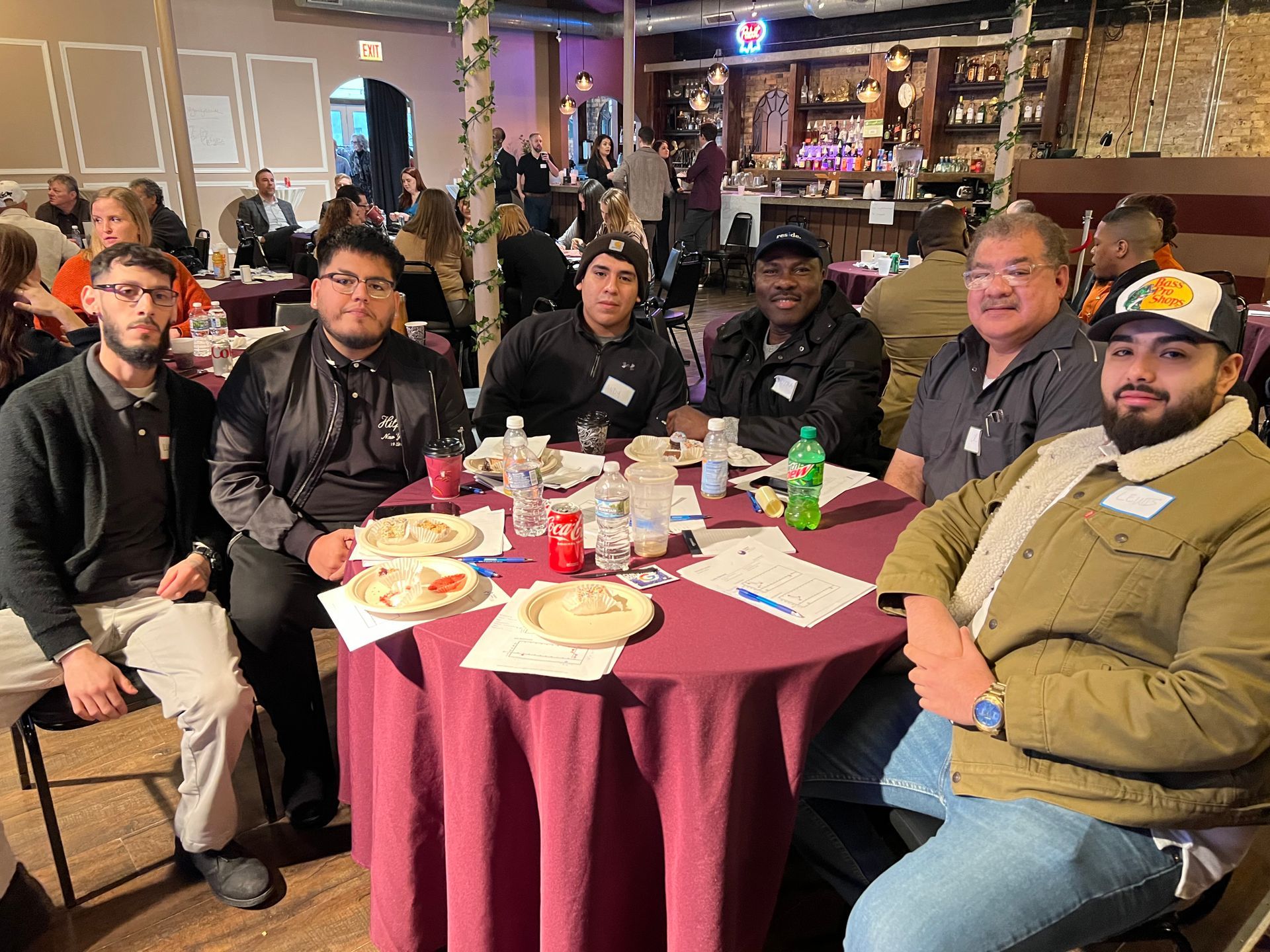 A group of men are sitting at a table in a restaurant.