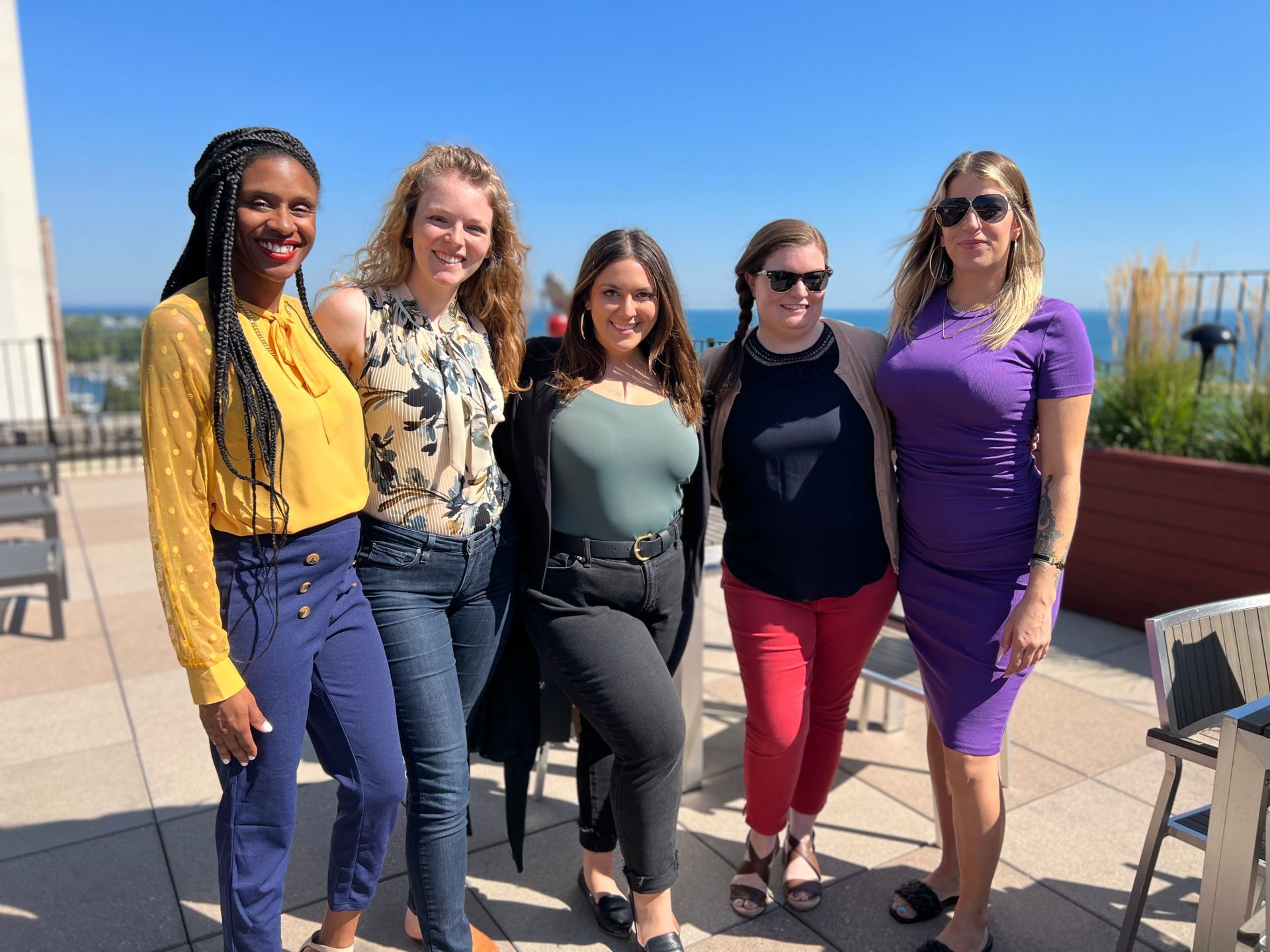 A group of women are posing for a picture on a rooftop.