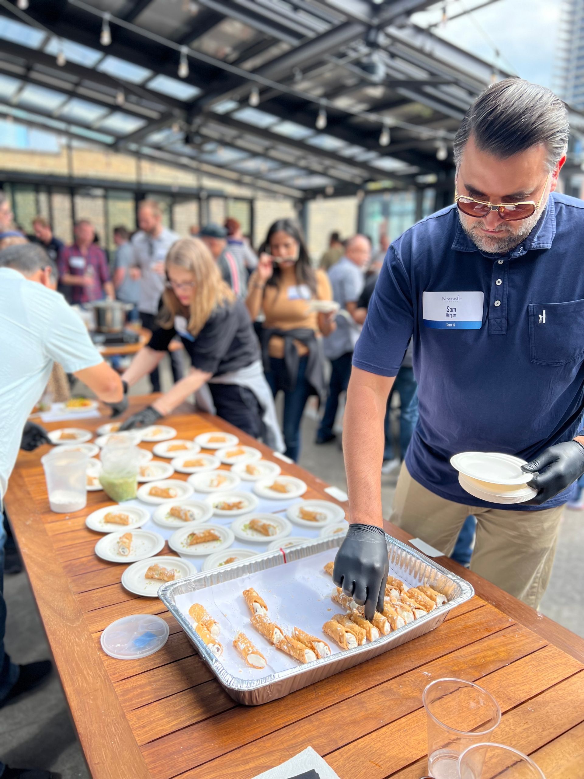 A man is serving food to a group of people at a table.