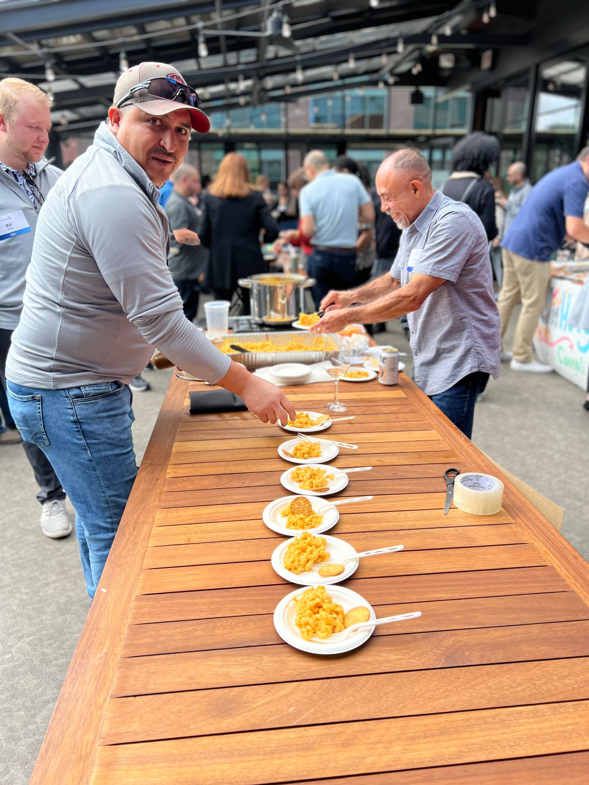 A group of men are standing around a table with plates of food on it.