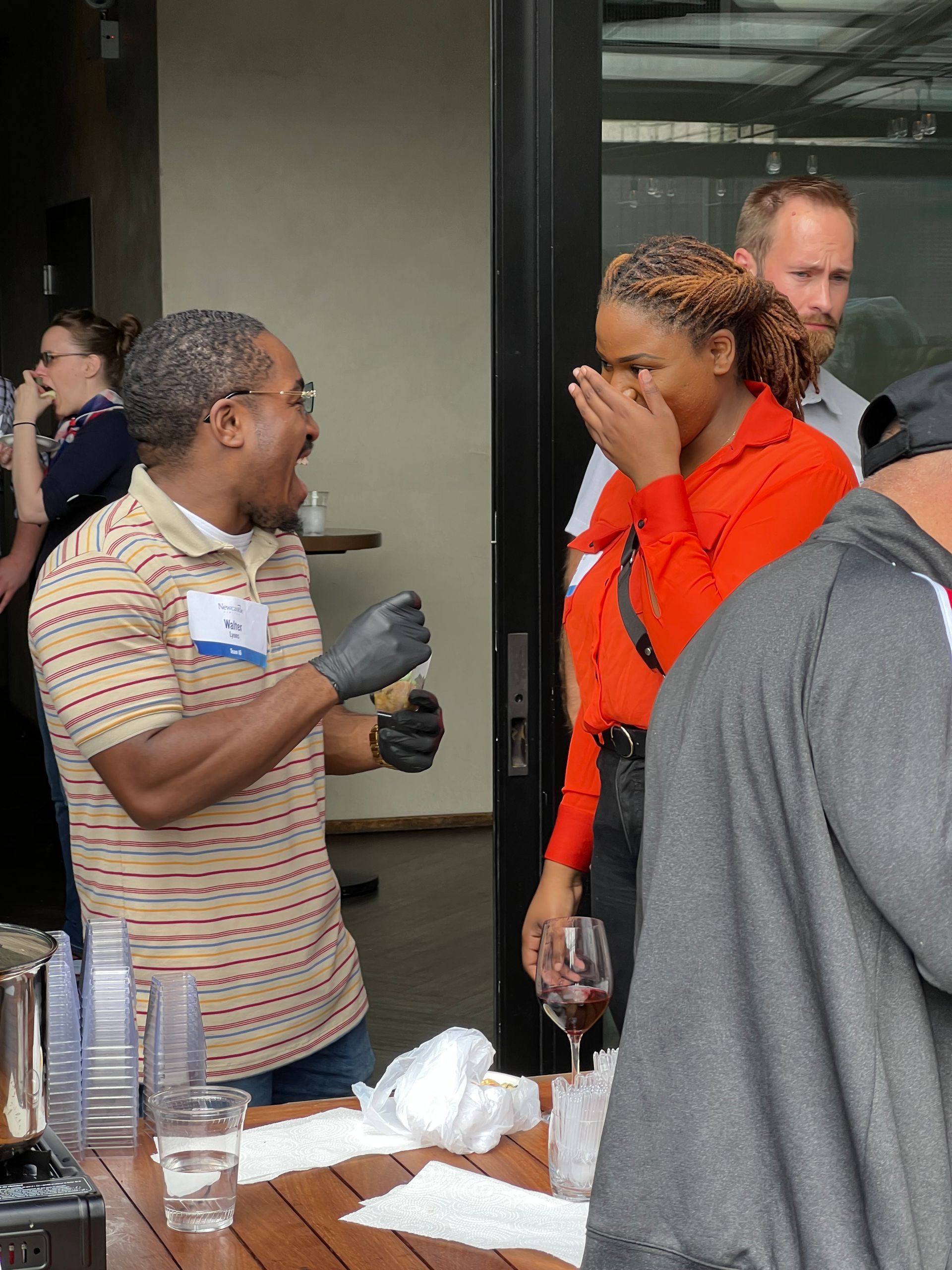A group of people are standing around a table talking to each other