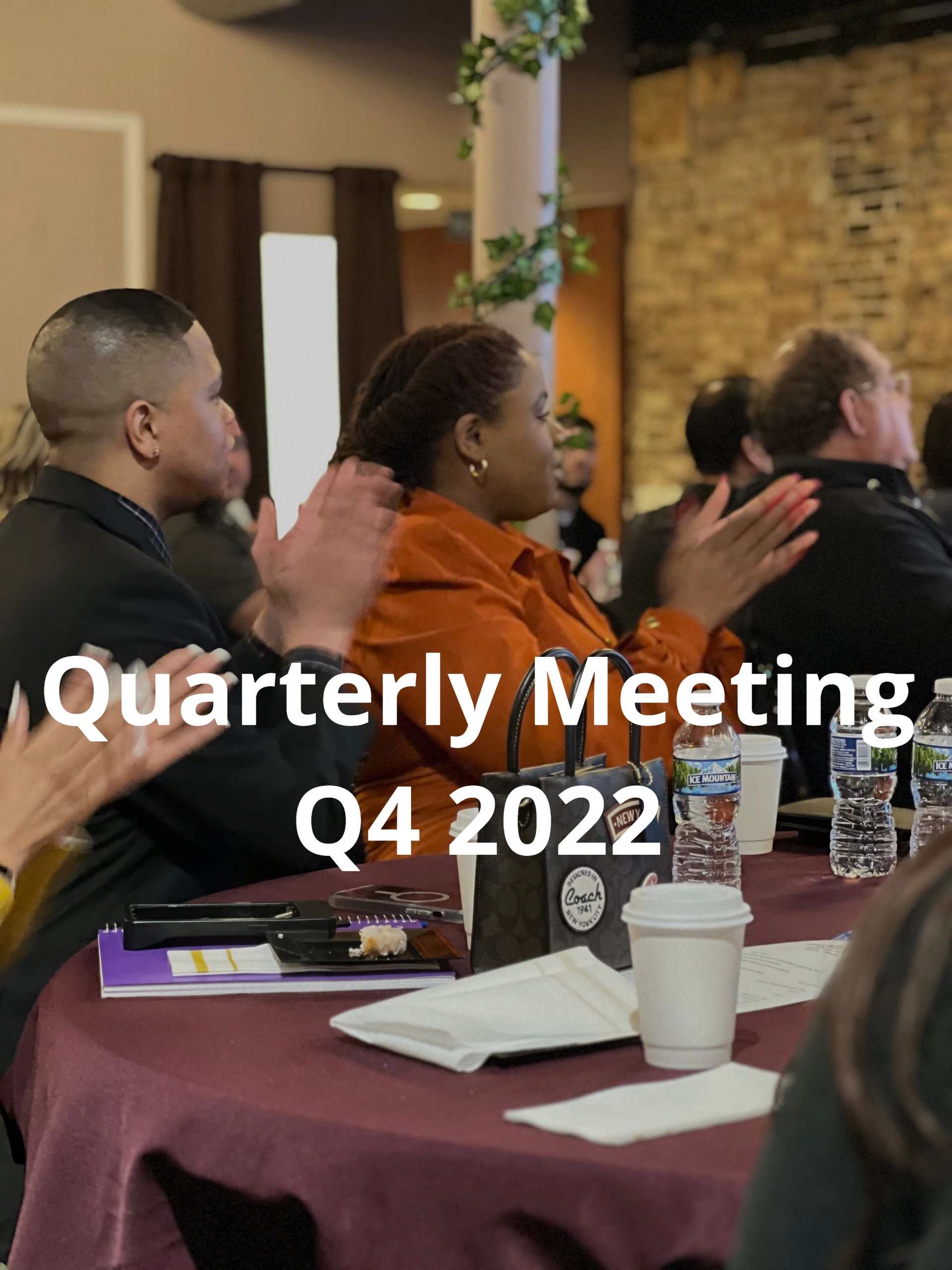 A group of people sitting at a table with the words quarterly meeting q4 2022