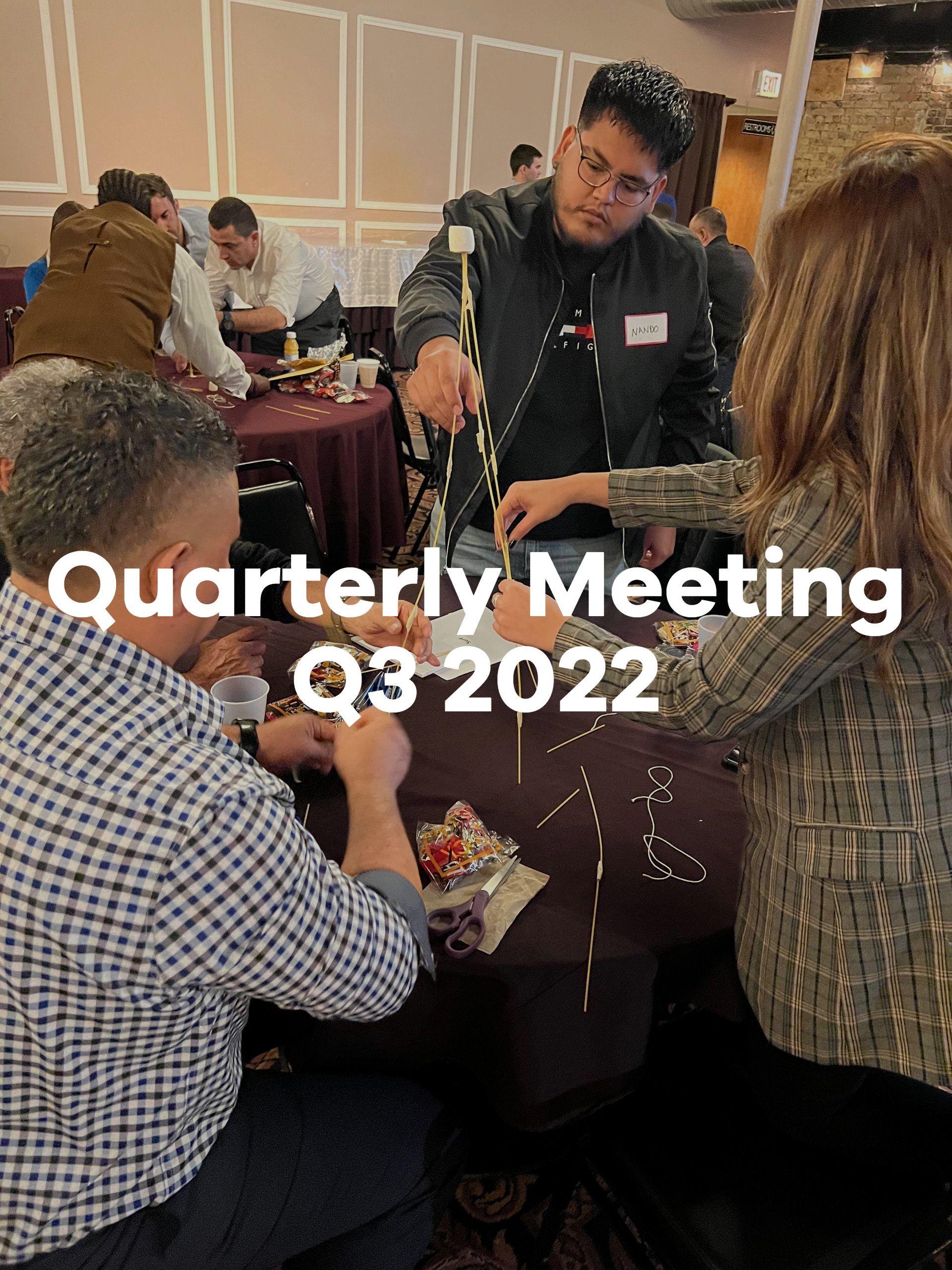A group of people are sitting around a table playing a game.