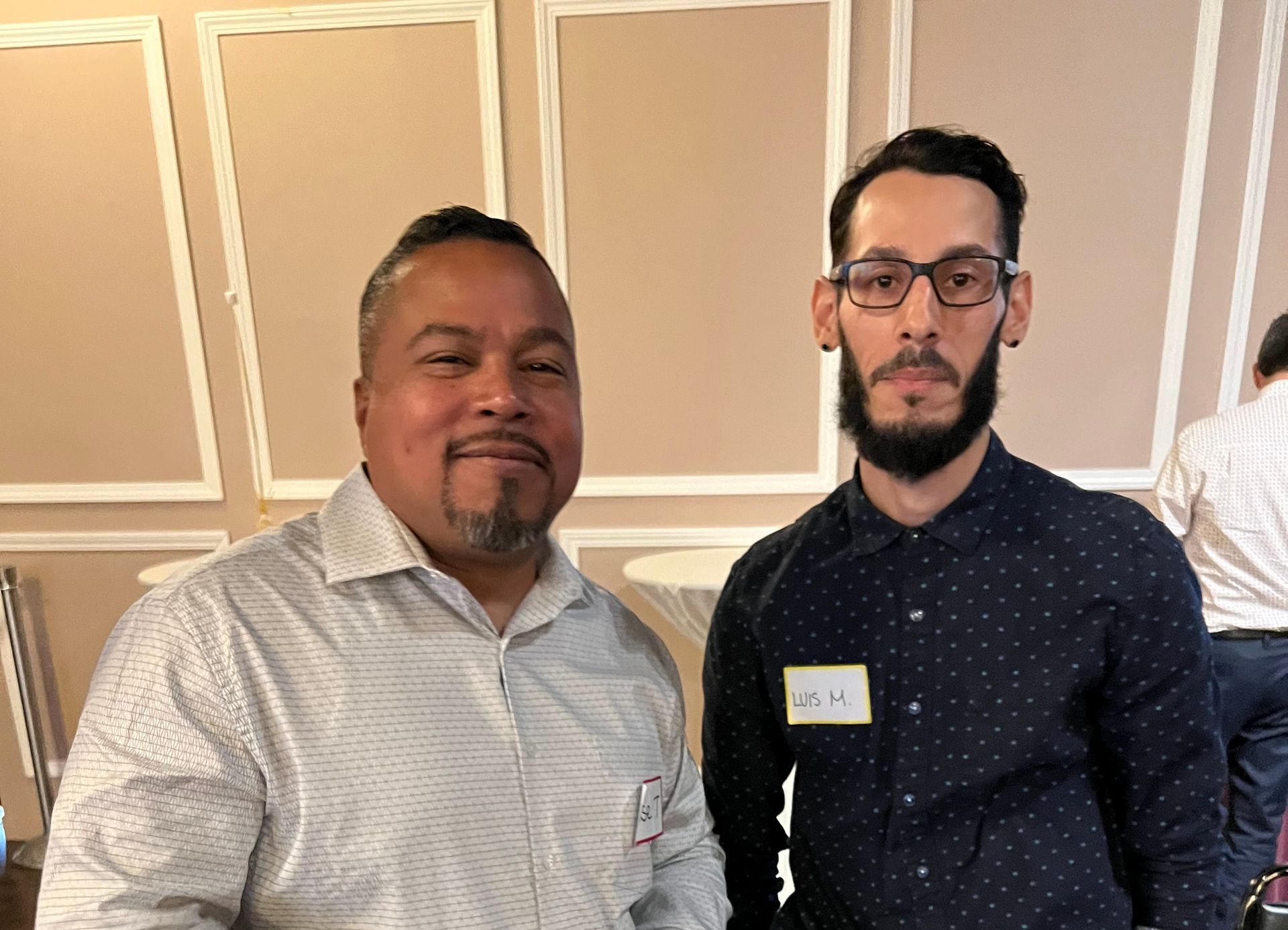 Two men are standing next to each other in a room.