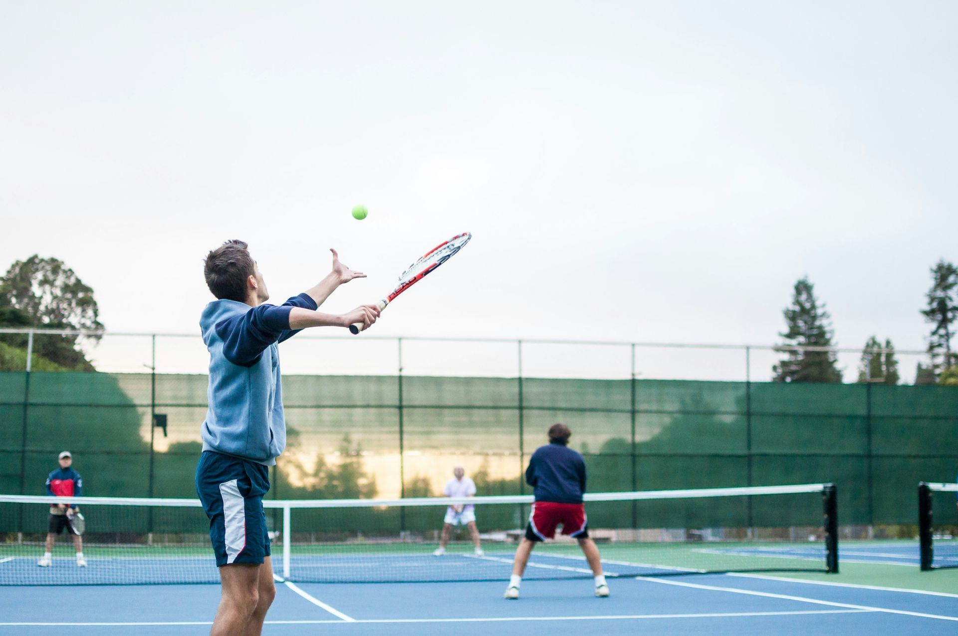 A man is hitting a tennis ball with a racket on a tennis court.