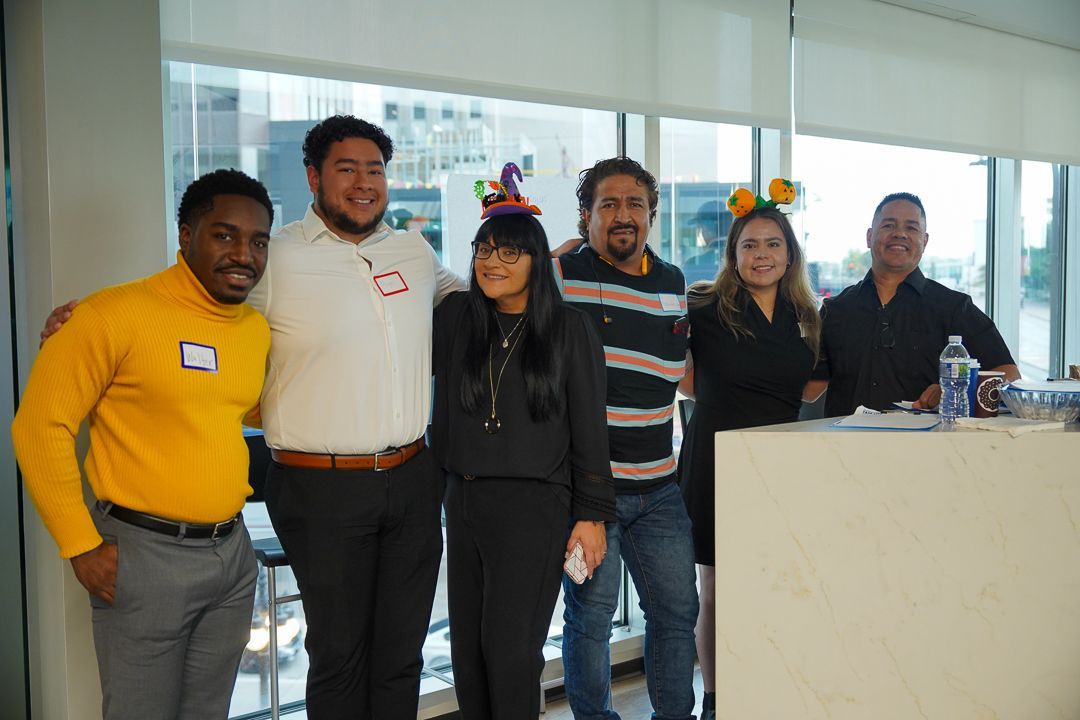 A group of people are posing for a picture in front of a window.