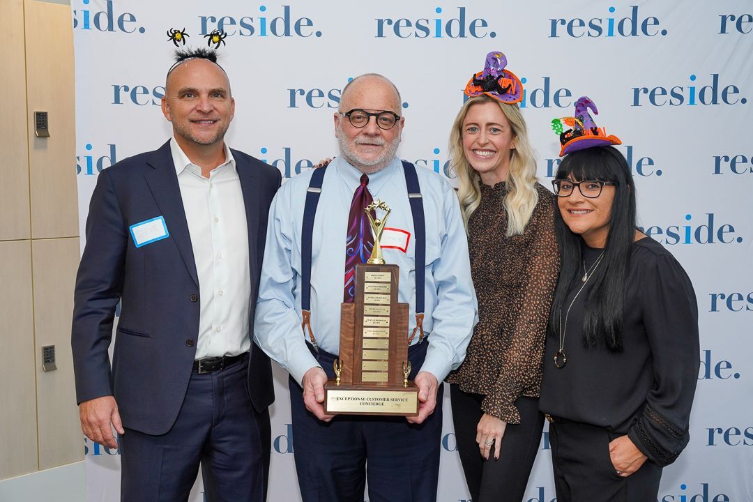 A group of people standing next to each other holding a trophy.