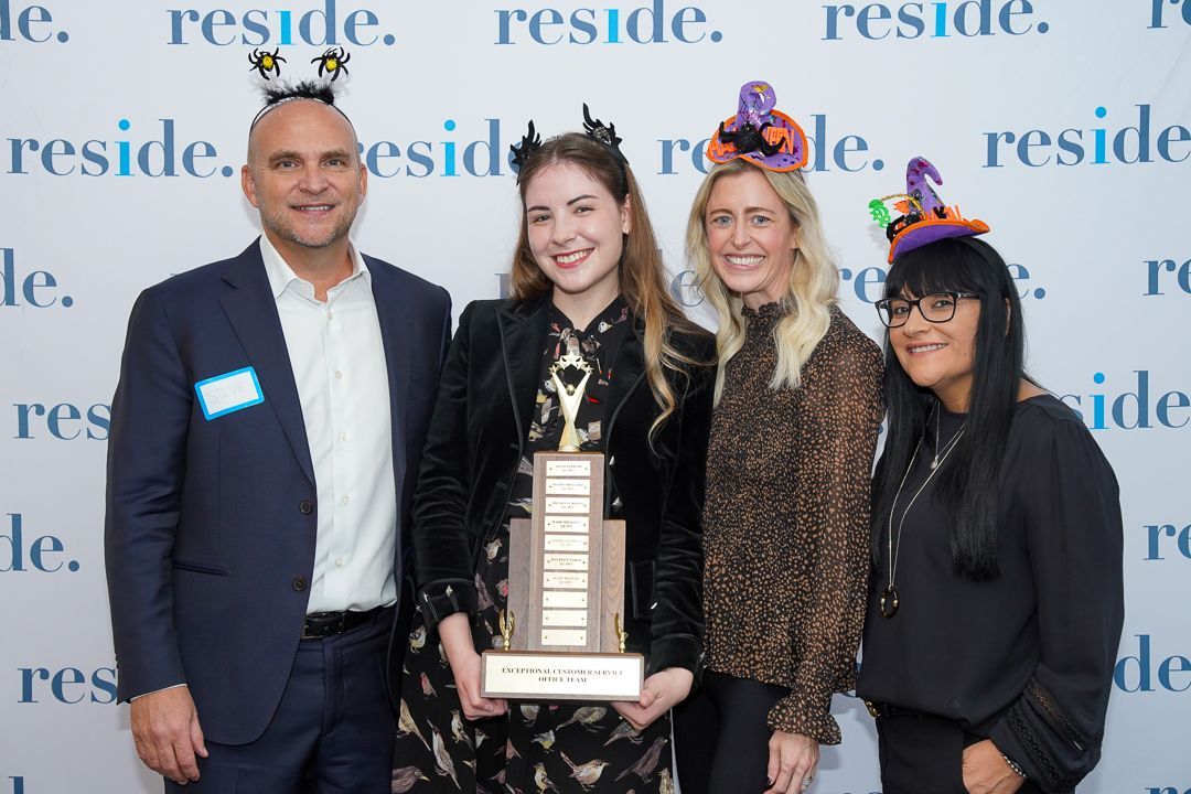 A group of people standing next to each other holding a trophy.