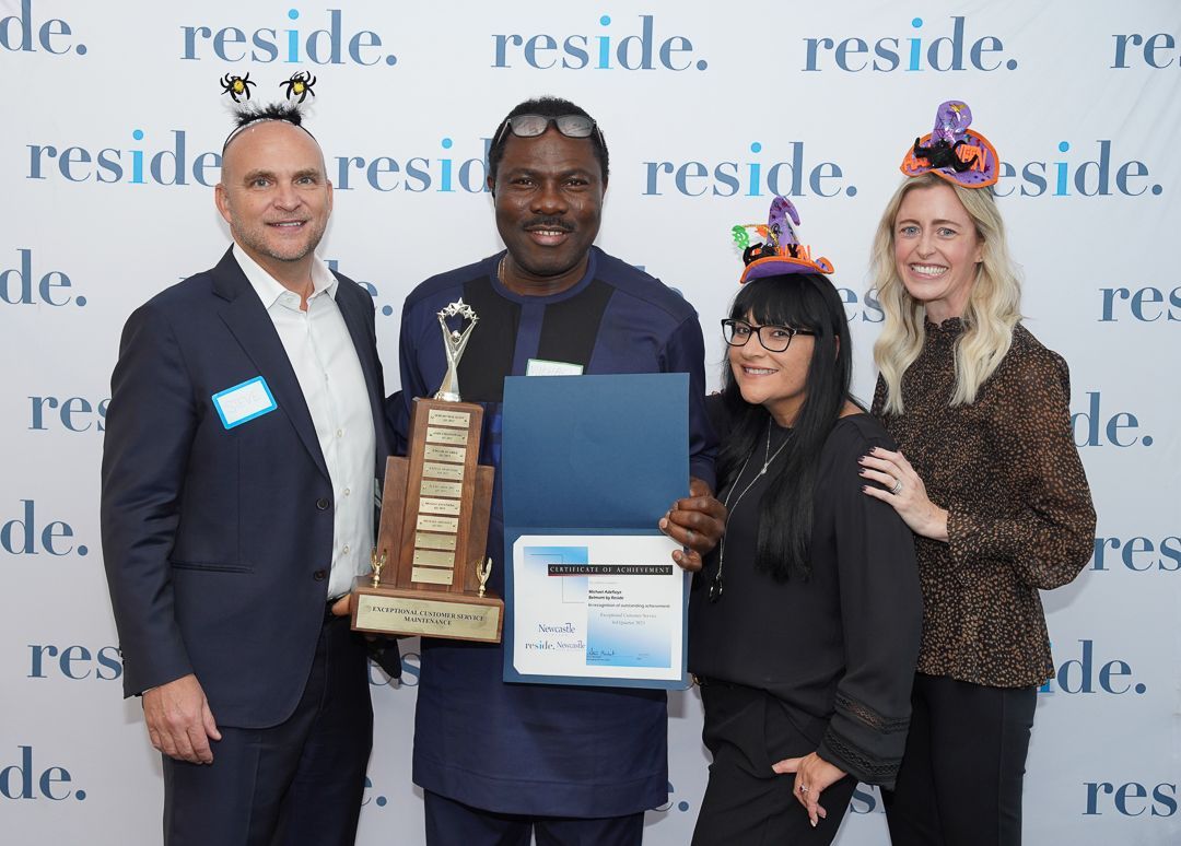 A group of people standing next to each other holding a trophy