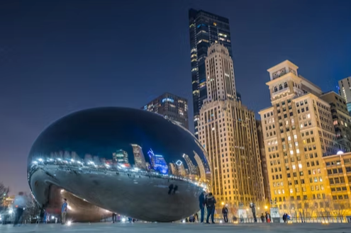 A large sculpture in the middle of a city at night.