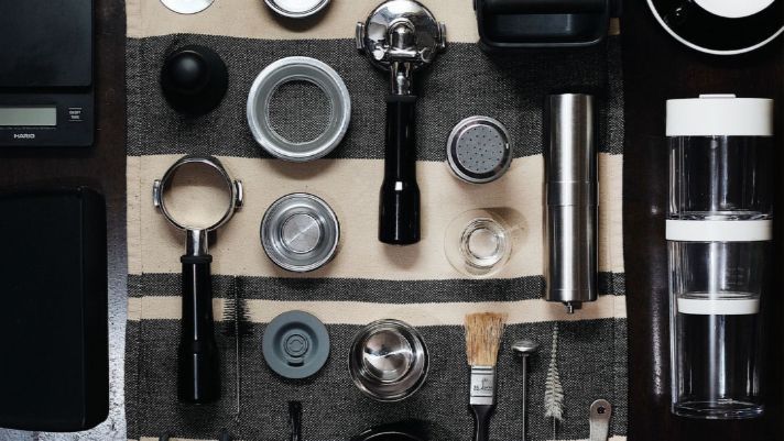 A bunch of coffee making tools are sitting on a table.