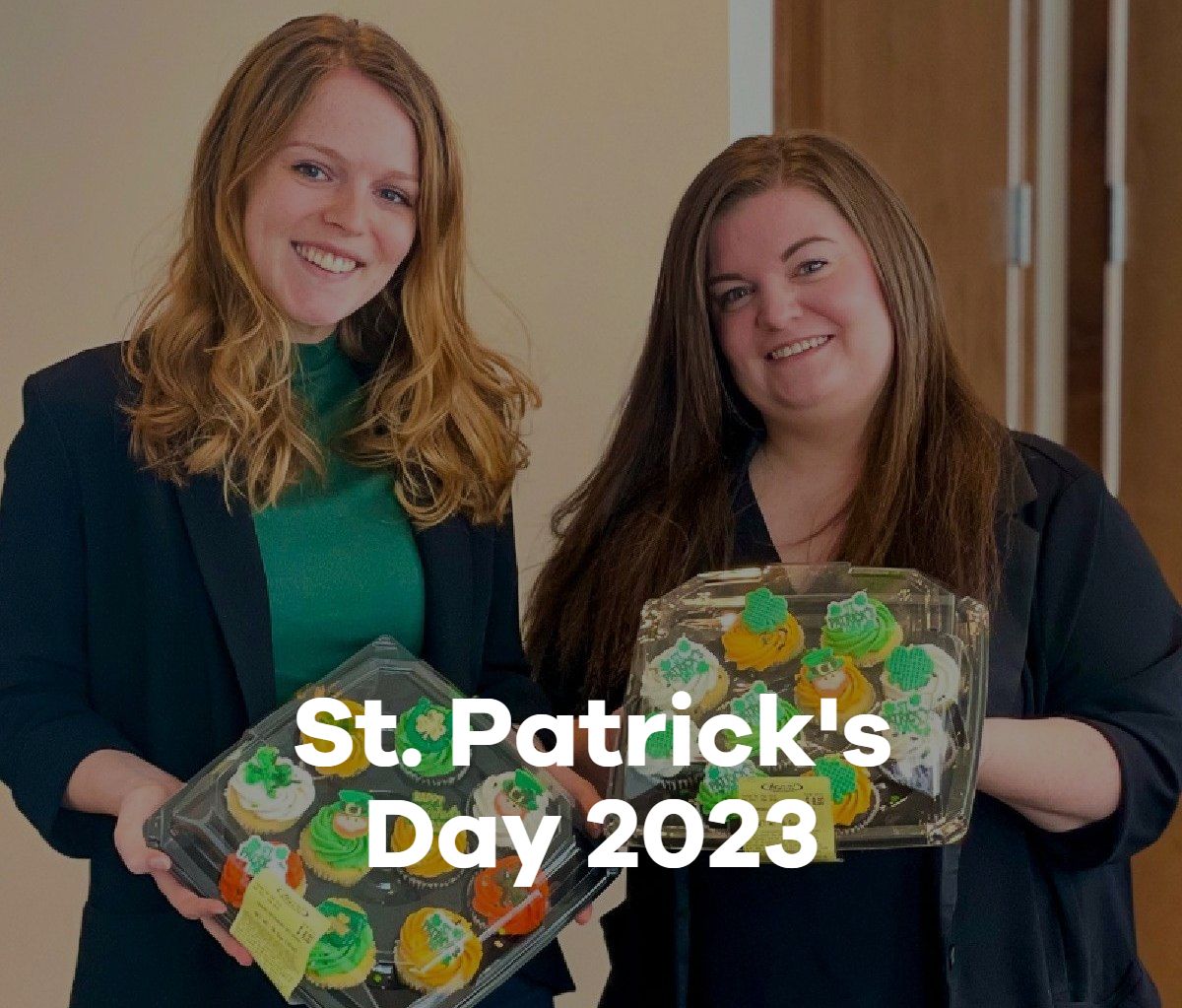 Two women are holding cupcakes for st. patrick 's day 2023.