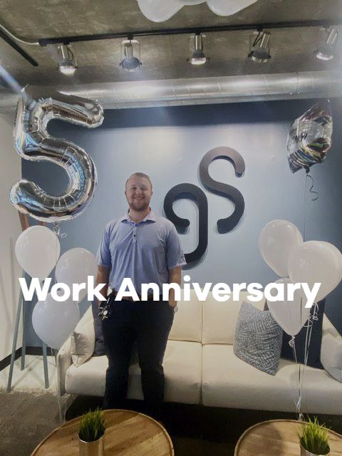 A man is standing in front of a wall with the number 5 on it