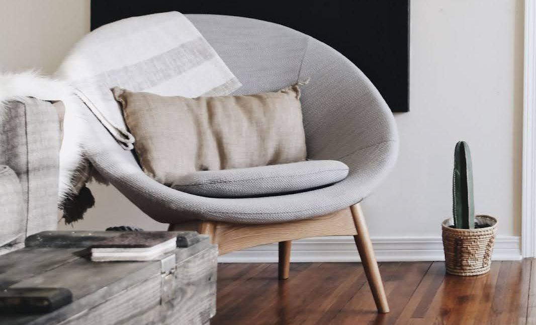 Round gray living room chair with pillow and blanket