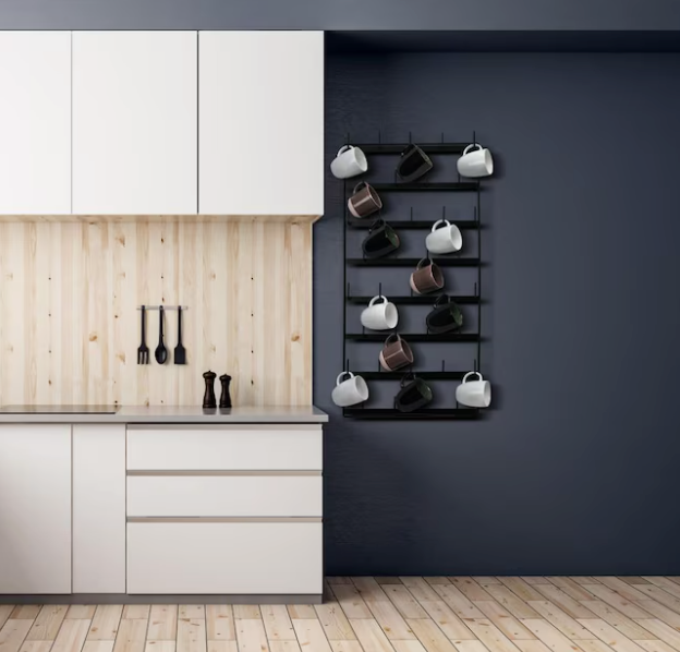 A modern kitchen with white cabinets, light wood walls, and a black mug rack on a dark blue wall.