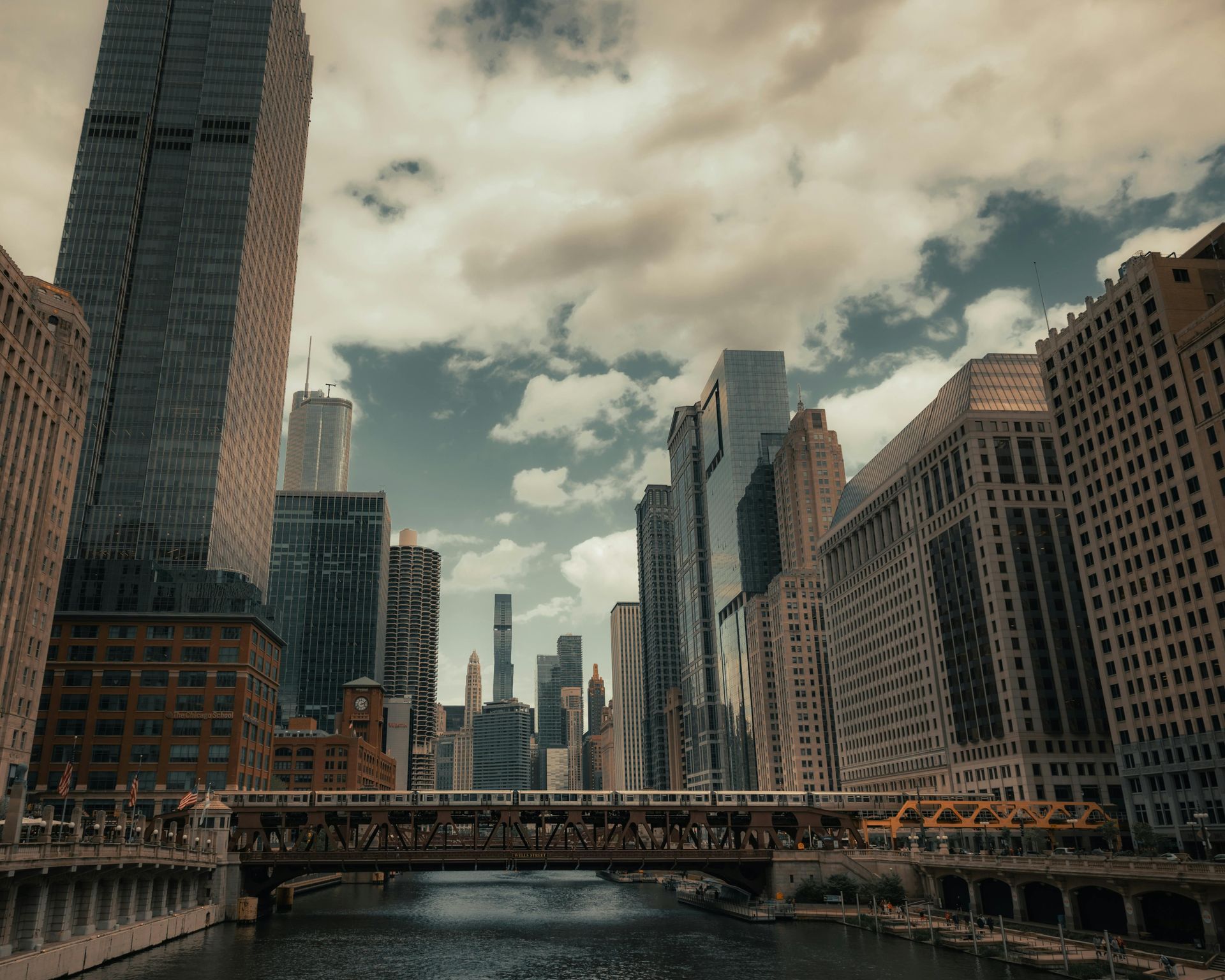 A city skyline with a bridge over a river in the foreground.