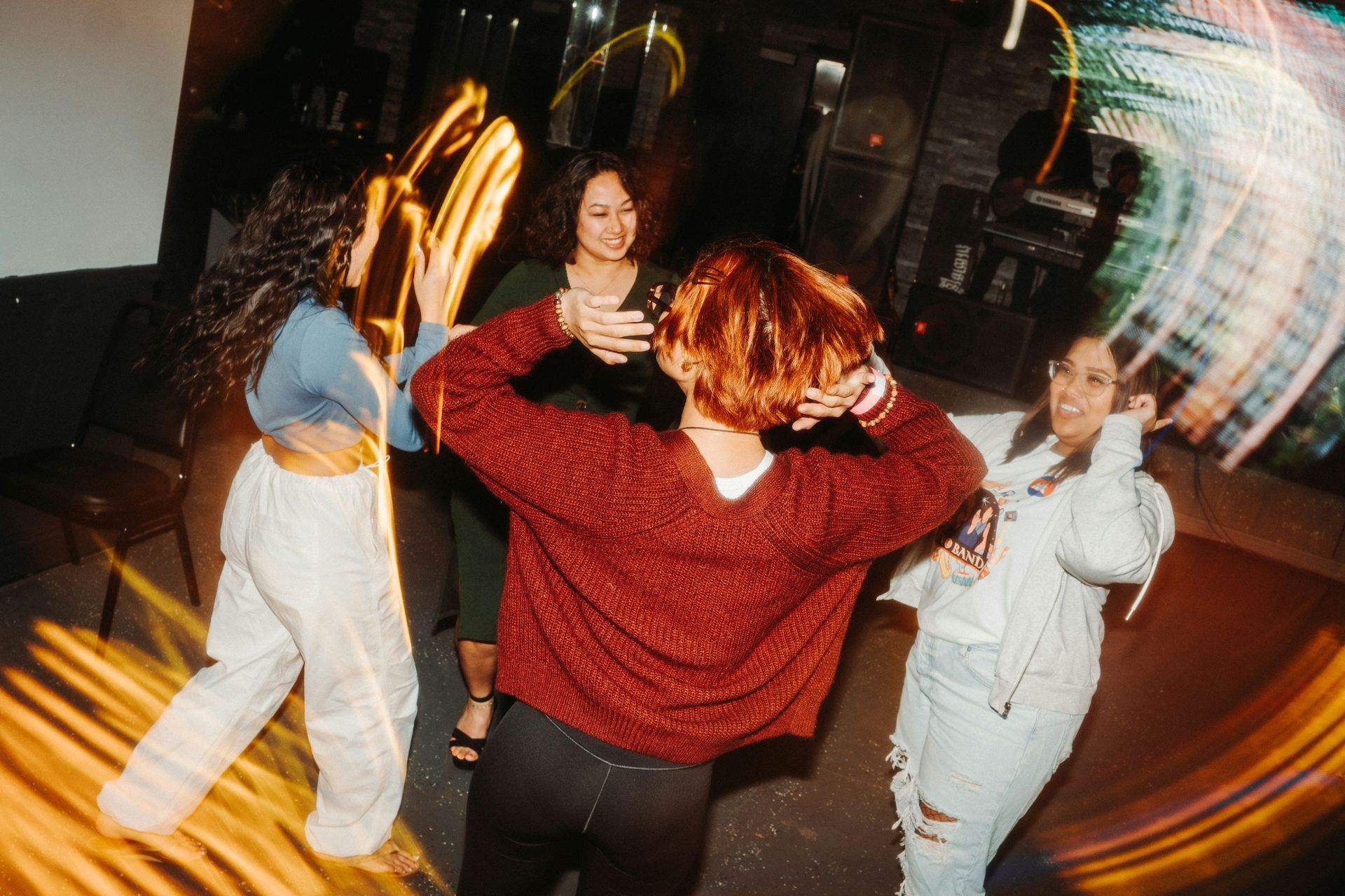 A group of women are dancing in a circle at a party.