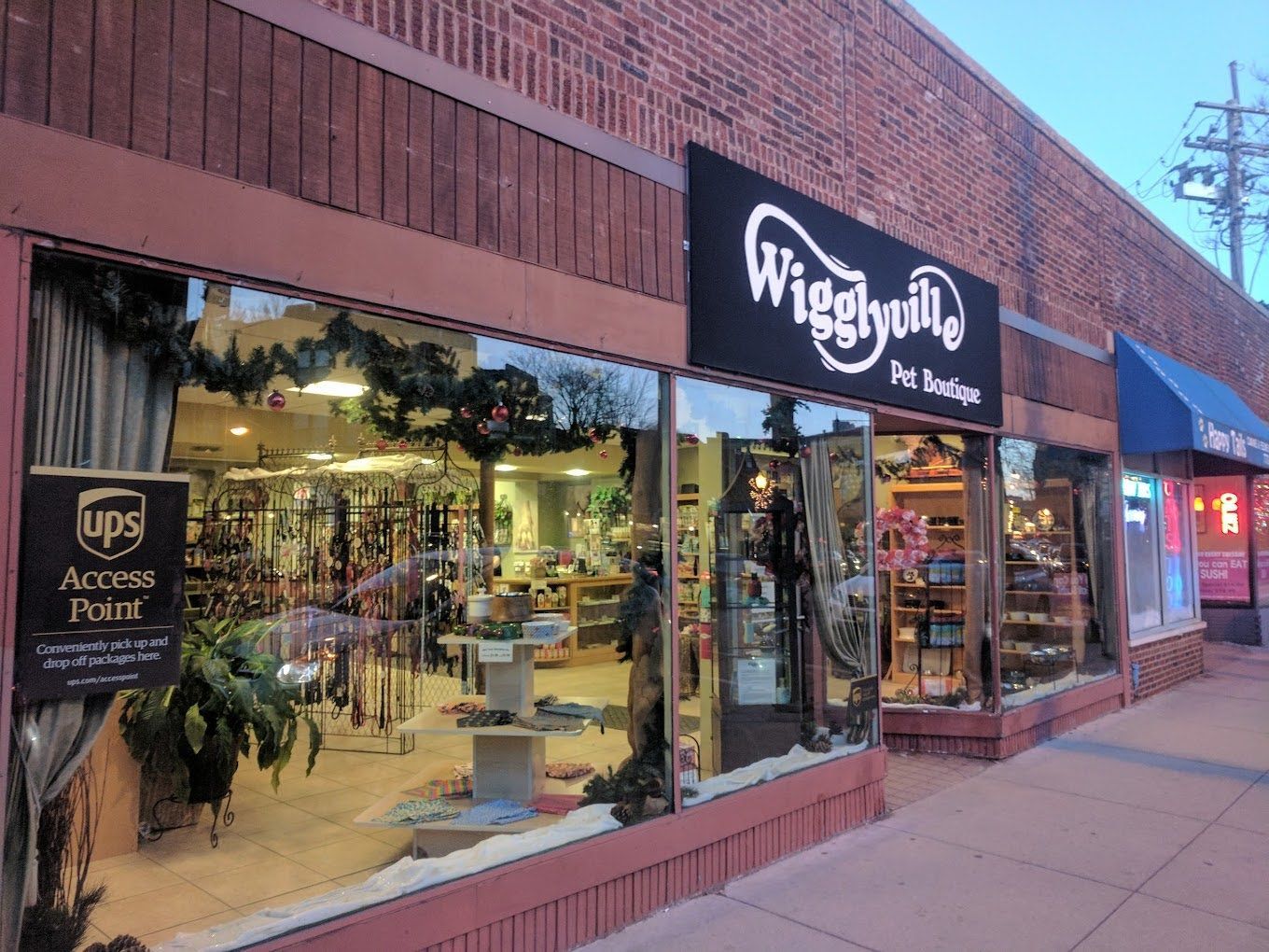 Wigglyvilla Pet Boutique store front with a brick exterior and large glass windows showcasing merchandise.