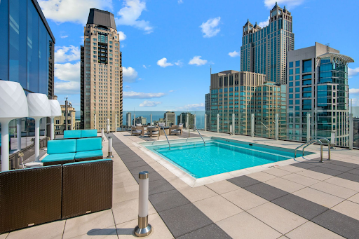 A swimming pool on a rooftop with a city skyline in the background.