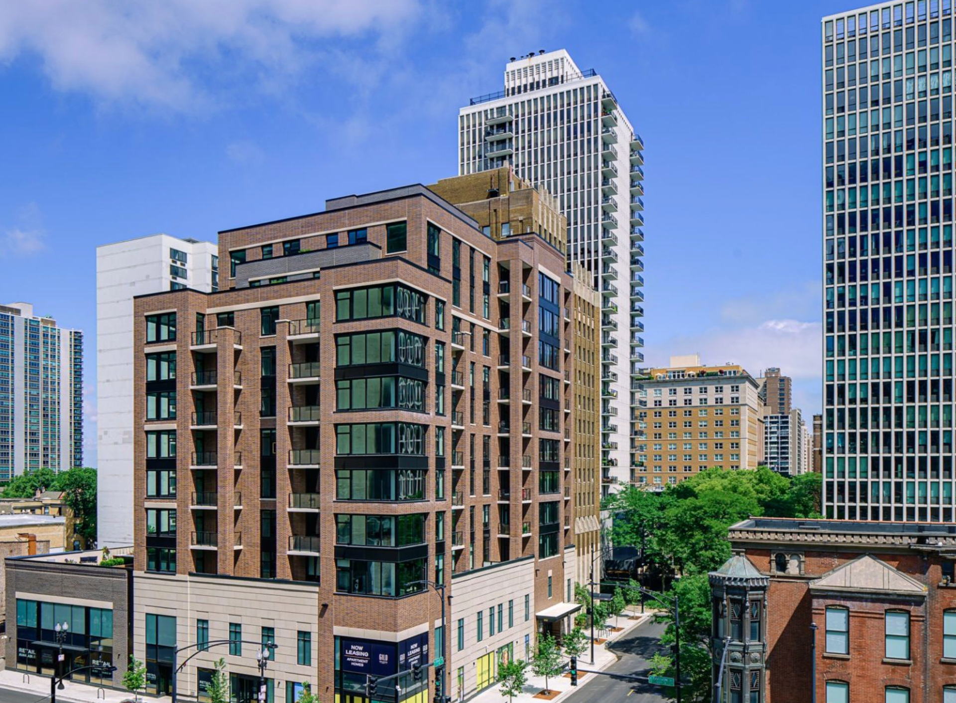 City skyline with tan and glass mid-rise buildings under a blue sky