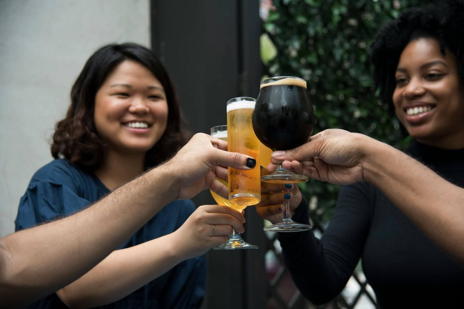 Two women clinking drinks