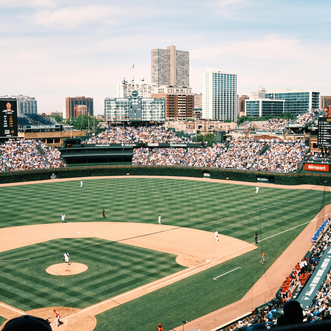 An aerial view of a baseball field with a city in the background in Chicago at Wrigleyville. 